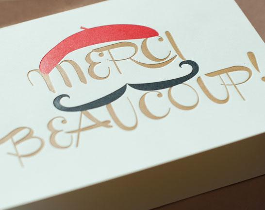 A stylish 'Merci Beaucoup' thank you card with a lined envelope, featuring debossed finishing and elegant design.