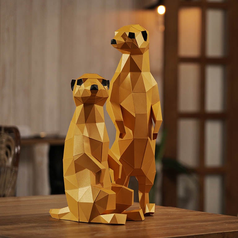 Two charming 3D paper meerkat models, one standing and one seated, showcasing intricate details and vibrant colors.