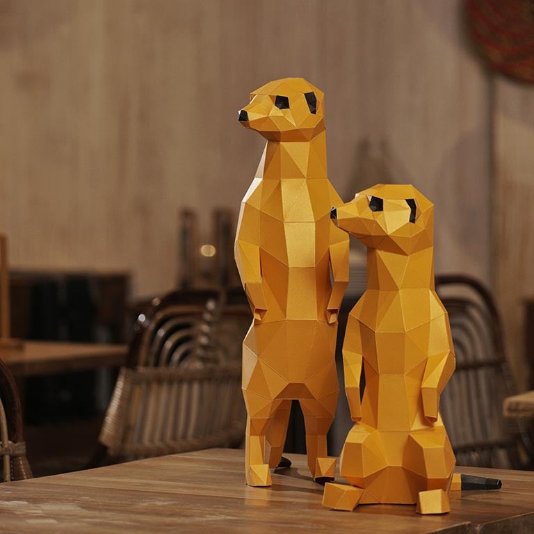 Two charming 3D paper meerkat models, one standing and one seated, showcasing intricate details and vibrant colors.