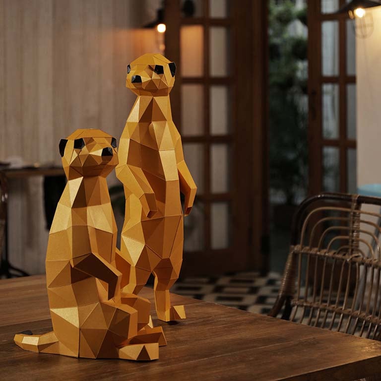 Two charming 3D paper meerkat models, one standing and one seated, showcasing intricate details and vibrant colors.