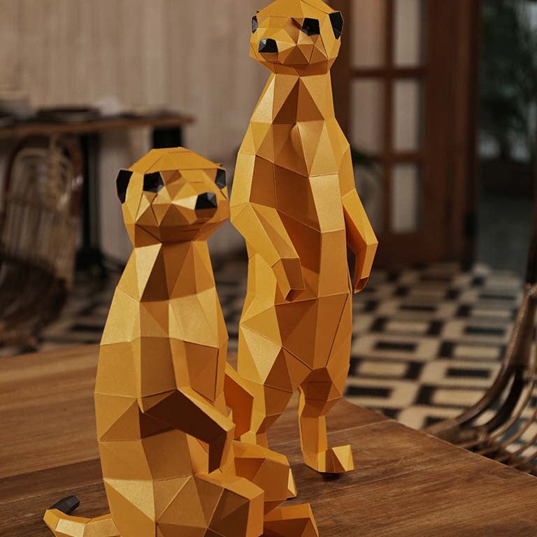 Two charming 3D paper meerkat models, one standing and one seated, showcasing intricate details and vibrant colors.