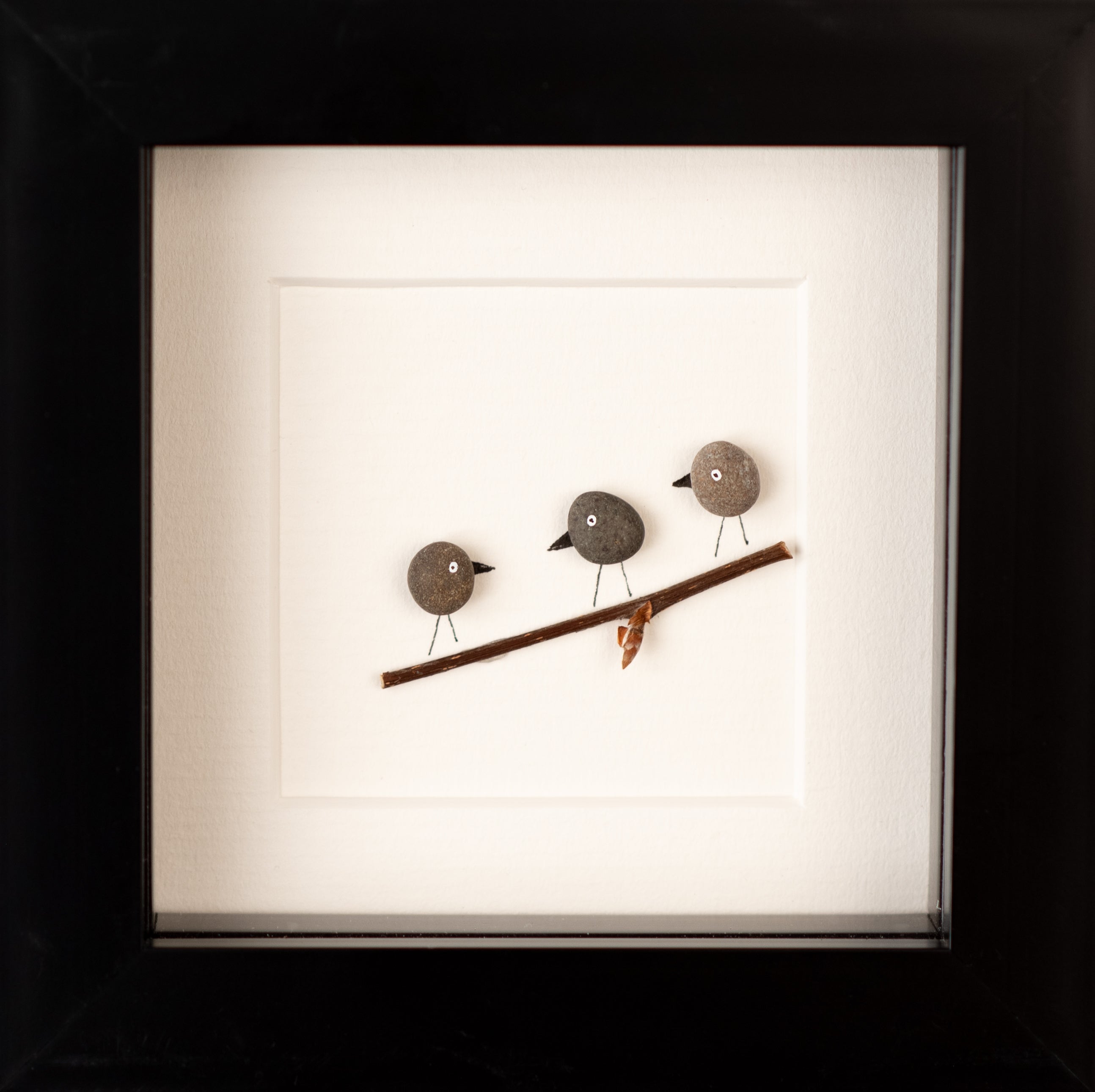 A collection of Mini Birds art pieces framed in white and black, showcasing vibrant colors and unique designs inspired by nature.