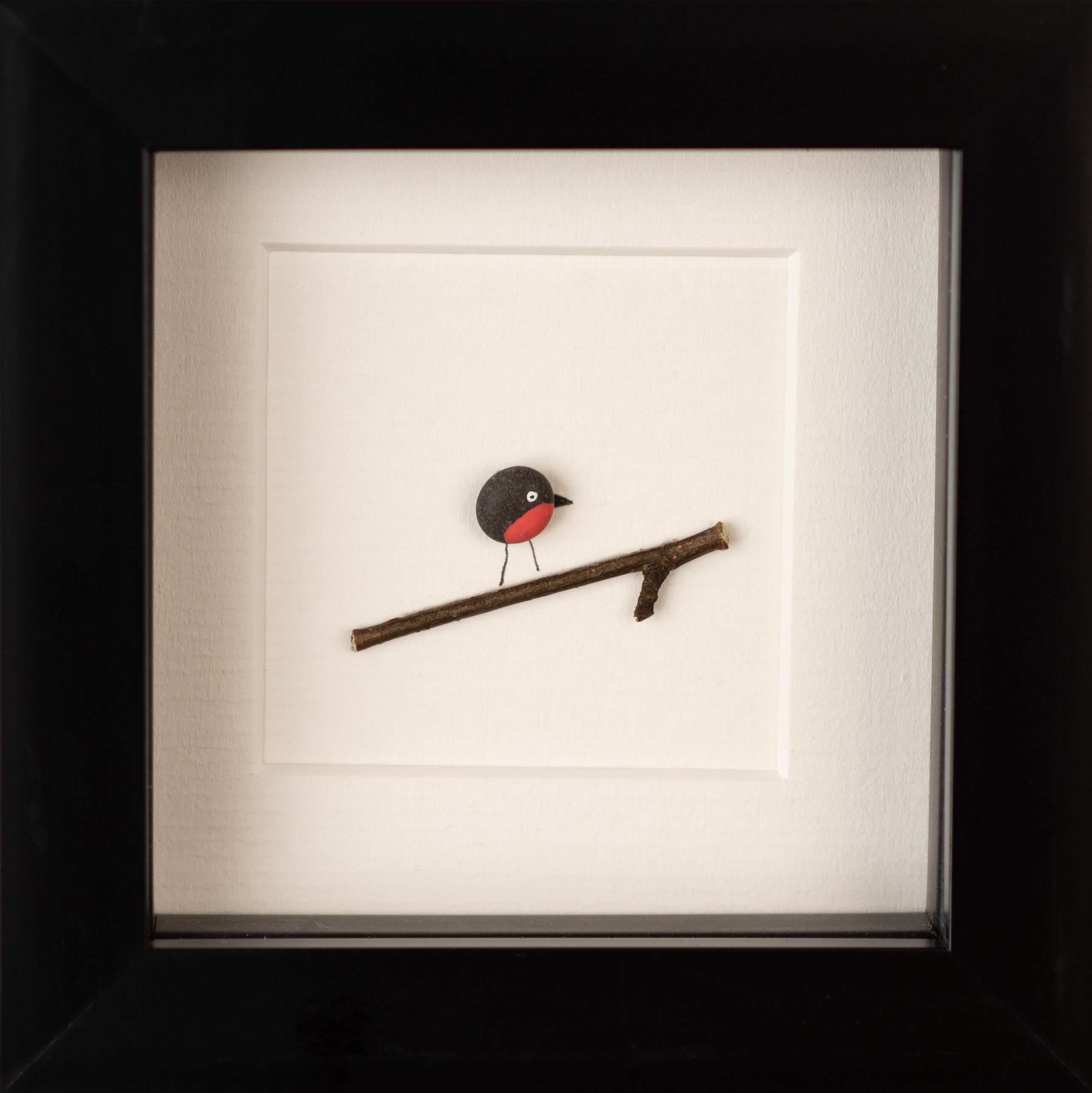 A beautifully crafted Mini Robin art piece framed in white, showcasing intricate details and natural materials, perfect for bird lovers.