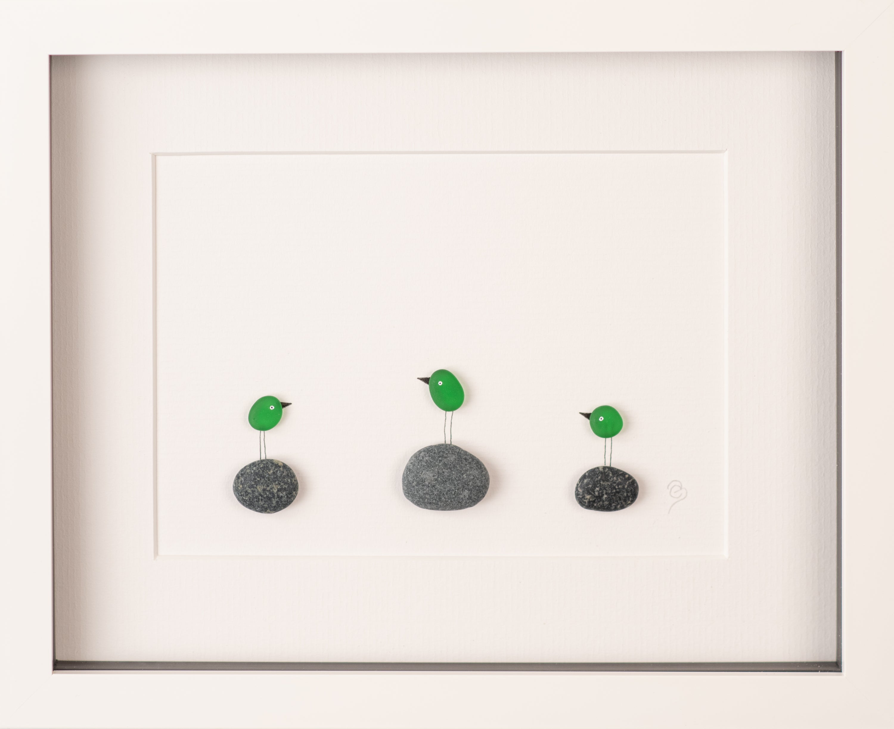 A collection of colorful Mini Sea Glass Birds displayed in elegant frames, showcasing their unique designs and natural materials.