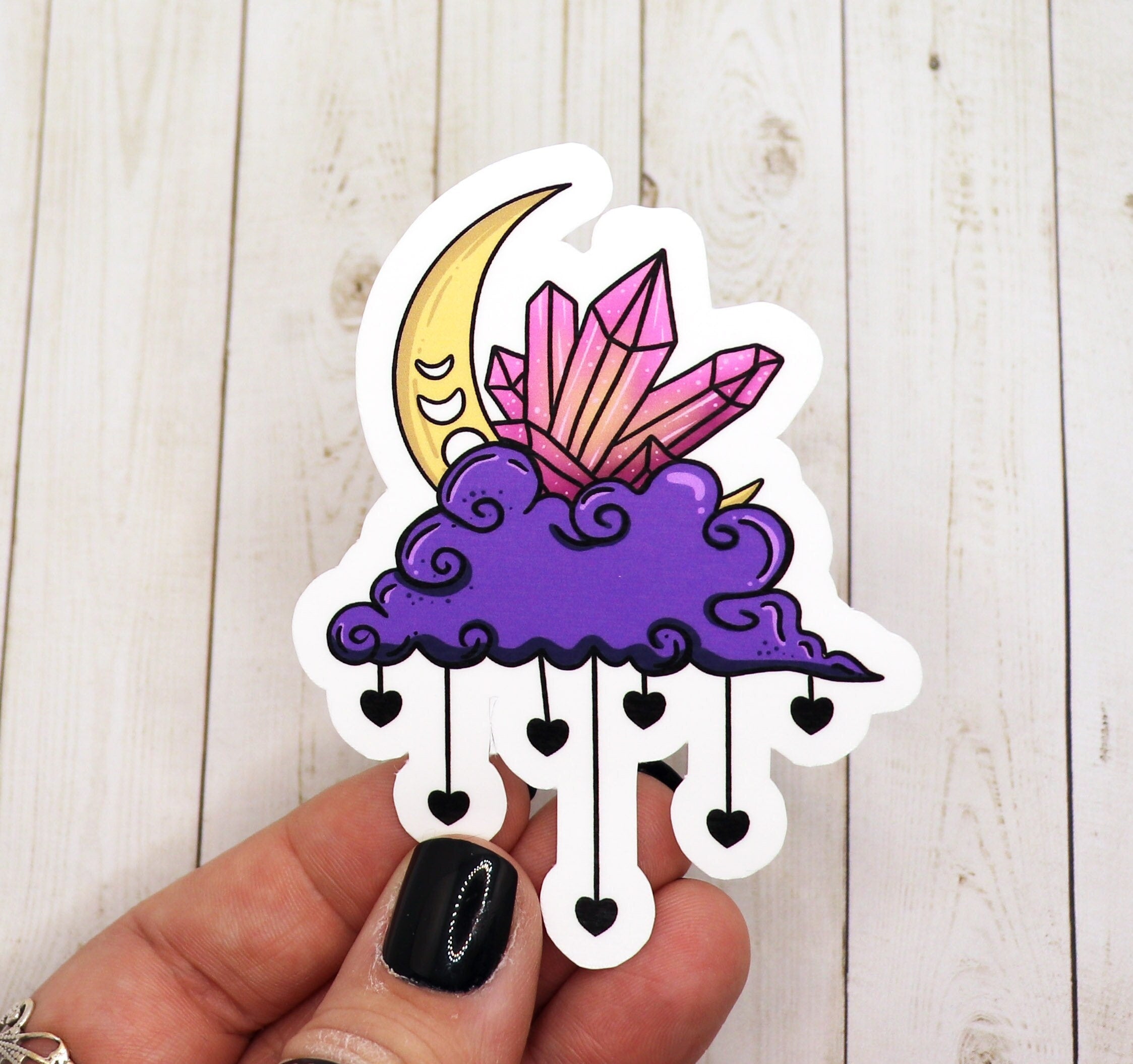 A beautifully designed Moon and Cloud Sticker featuring a whimsical moon and fluffy clouds on a matte vinyl surface.