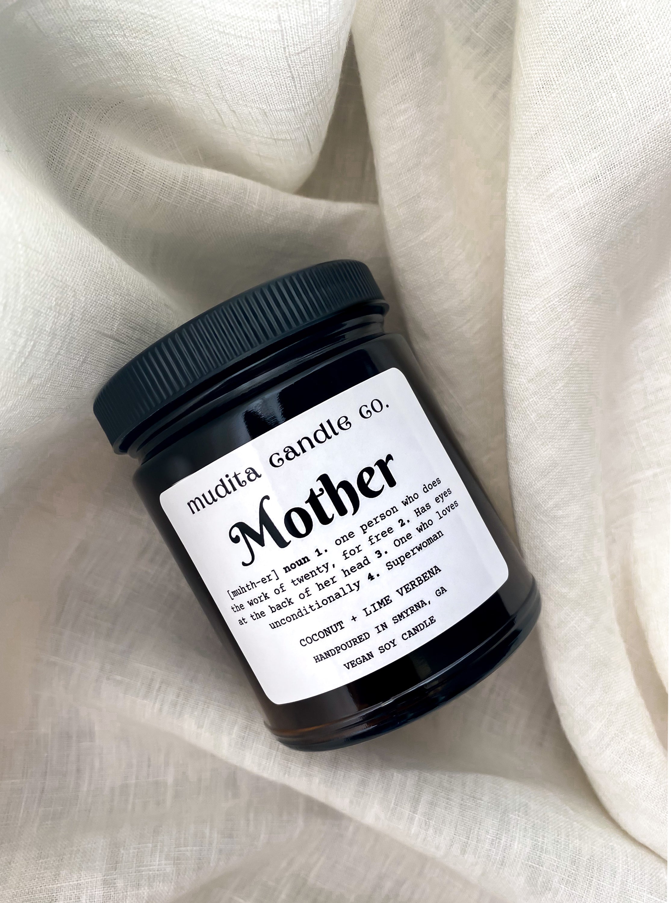 Mother (Definition) 9oz Candle in amber glass jar with black lid, featuring tropical coconut and lime scent.