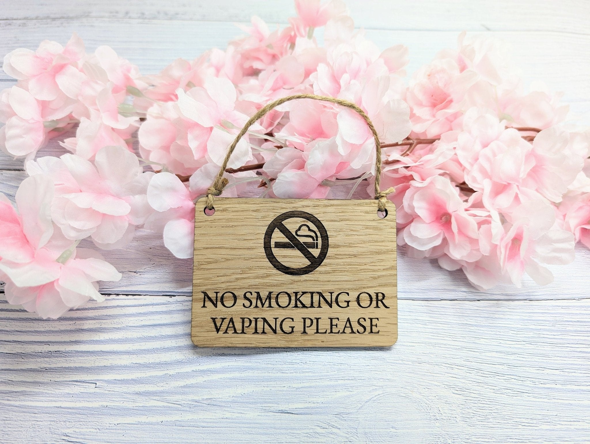 A beautifully crafted 'No Smoking or Vaping Please' wooden sign made from oak veneered MDF, showcasing its unique grain and craftsmanship.