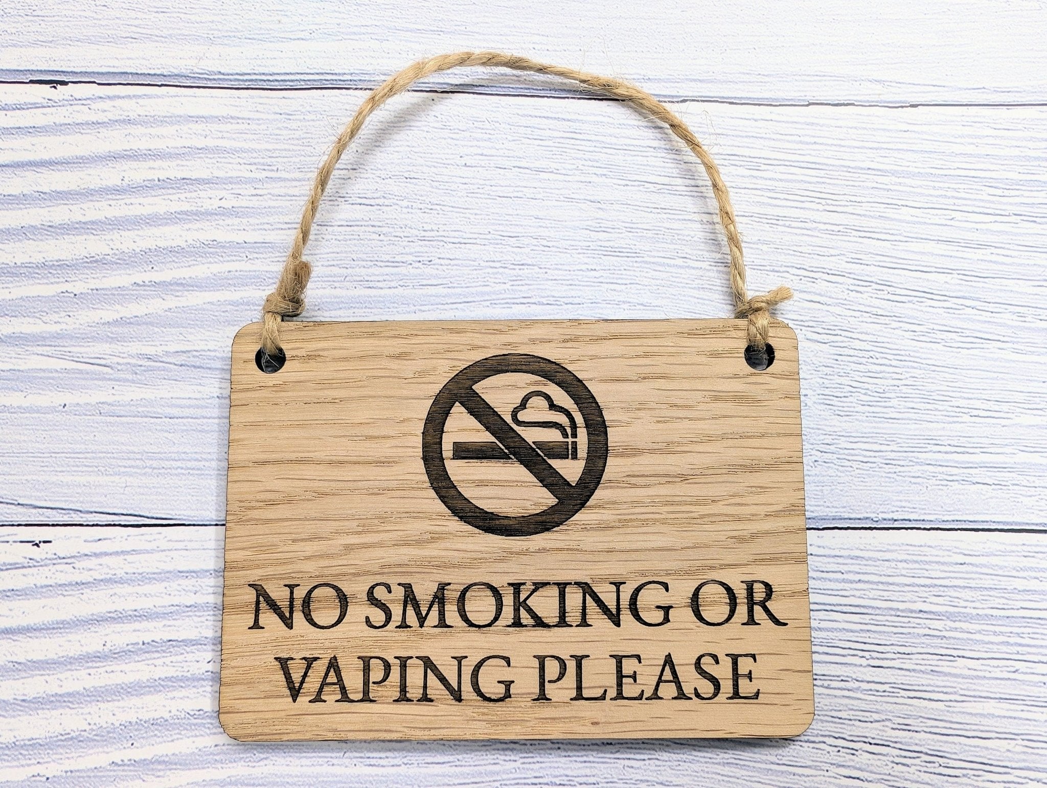 A beautifully crafted 'No Smoking or Vaping Please' wooden sign made from oak veneered MDF, showcasing its unique grain and craftsmanship.