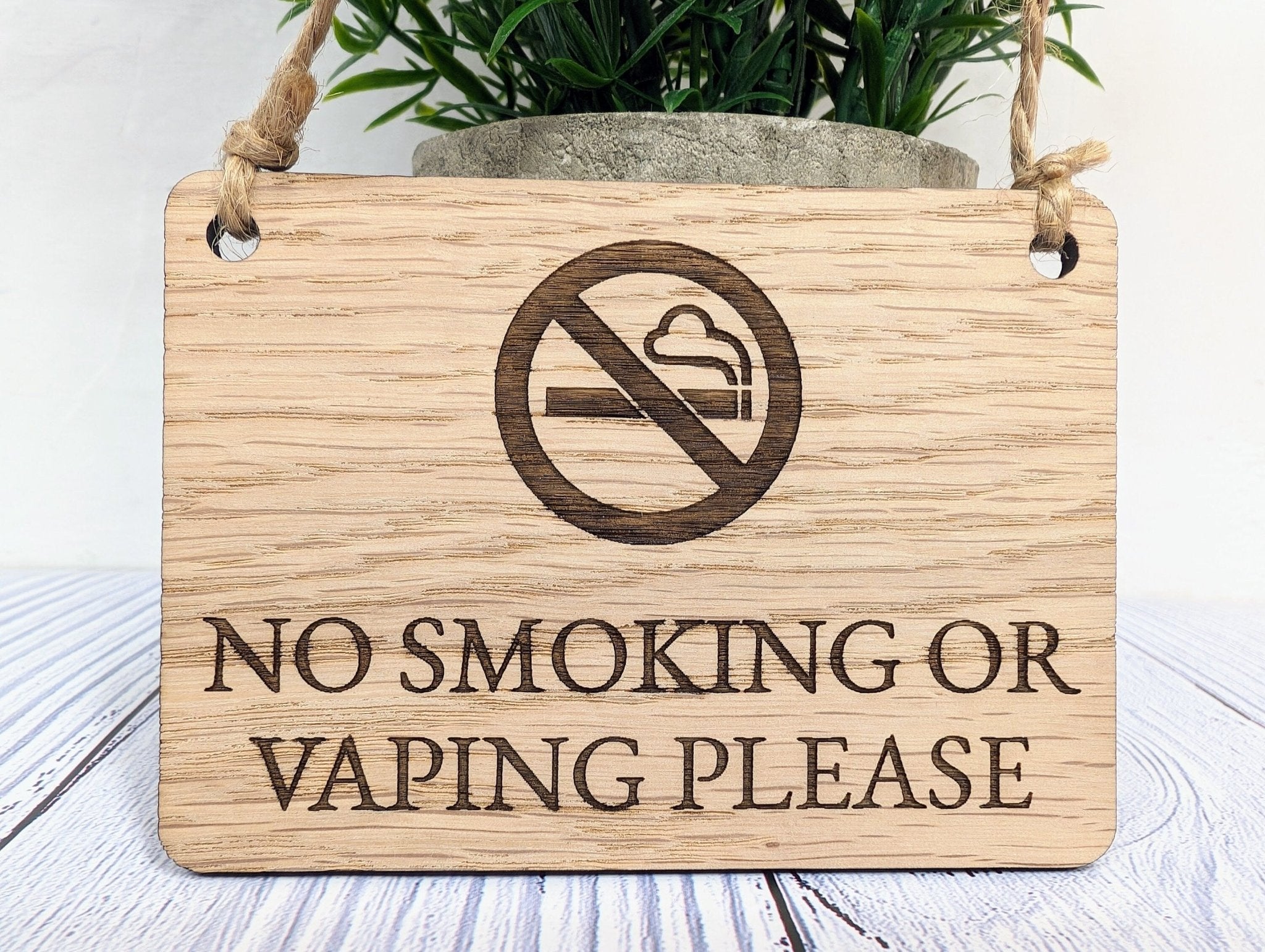 A beautifully crafted 'No Smoking or Vaping Please' wooden sign made from oak veneered MDF, showcasing its unique grain and craftsmanship.