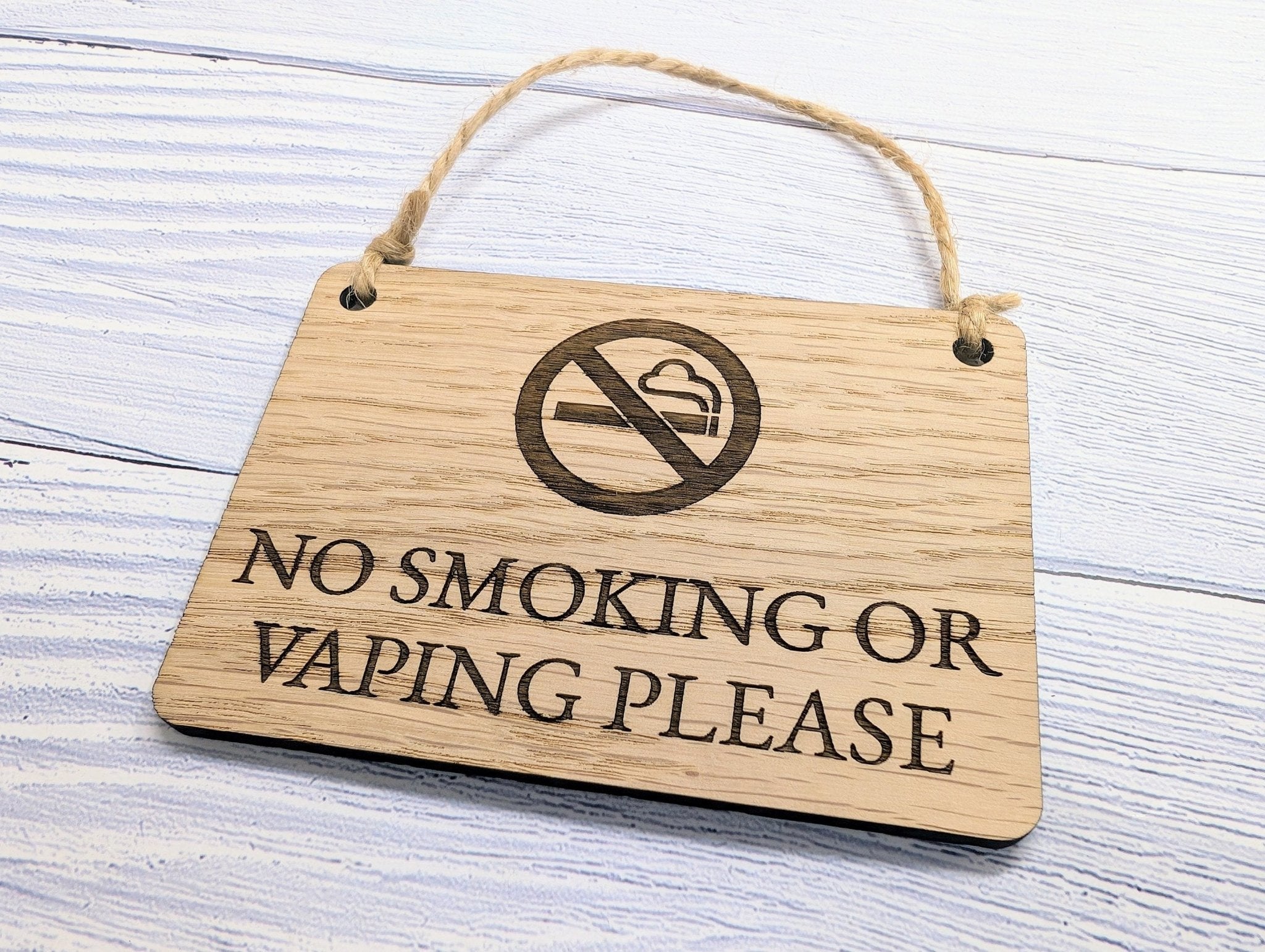 A beautifully crafted 'No Smoking or Vaping Please' wooden sign made from oak veneered MDF, showcasing its unique grain and craftsmanship.