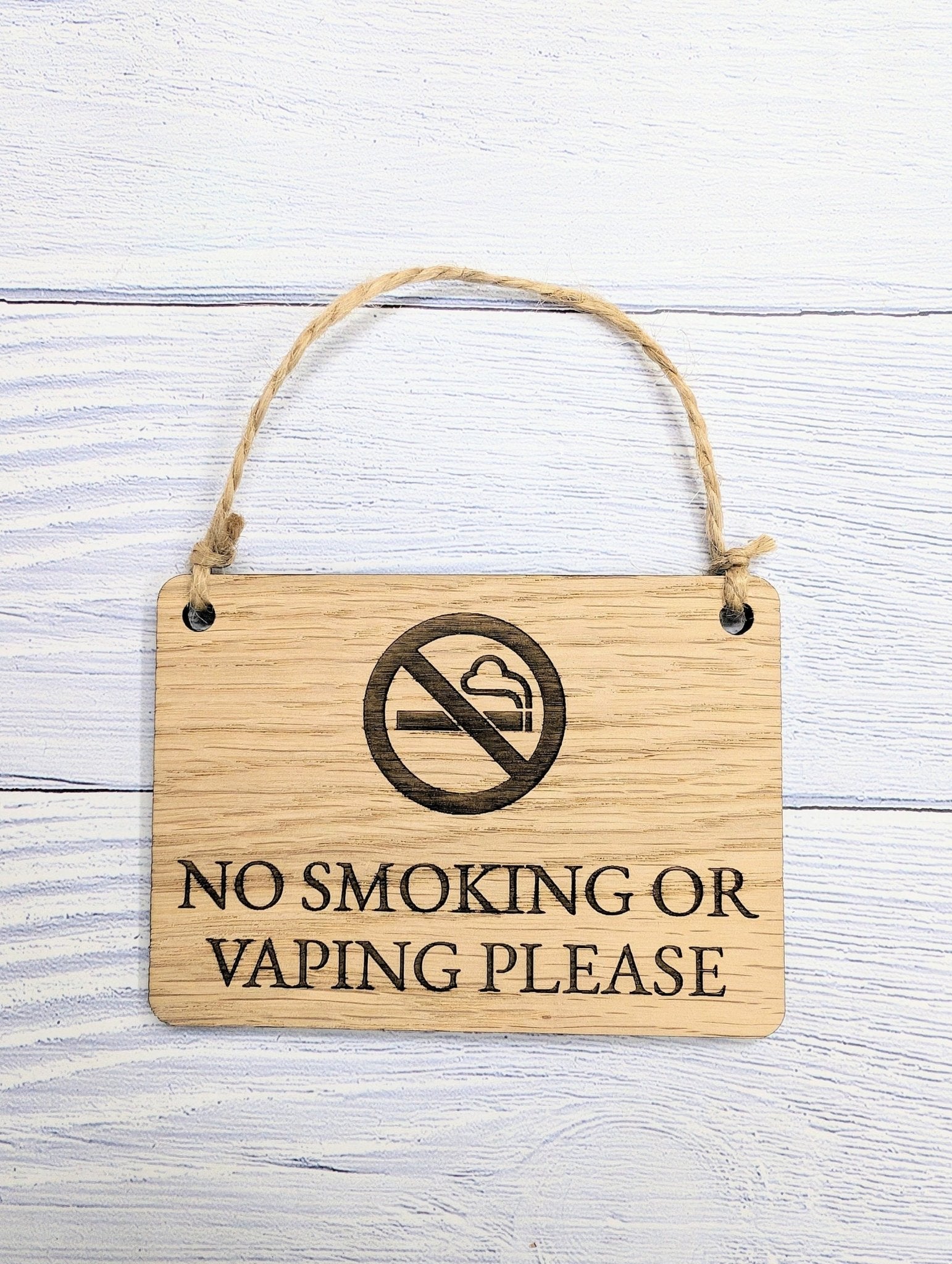 A beautifully crafted 'No Smoking or Vaping Please' wooden sign made from oak veneered MDF, showcasing its unique grain and craftsmanship.