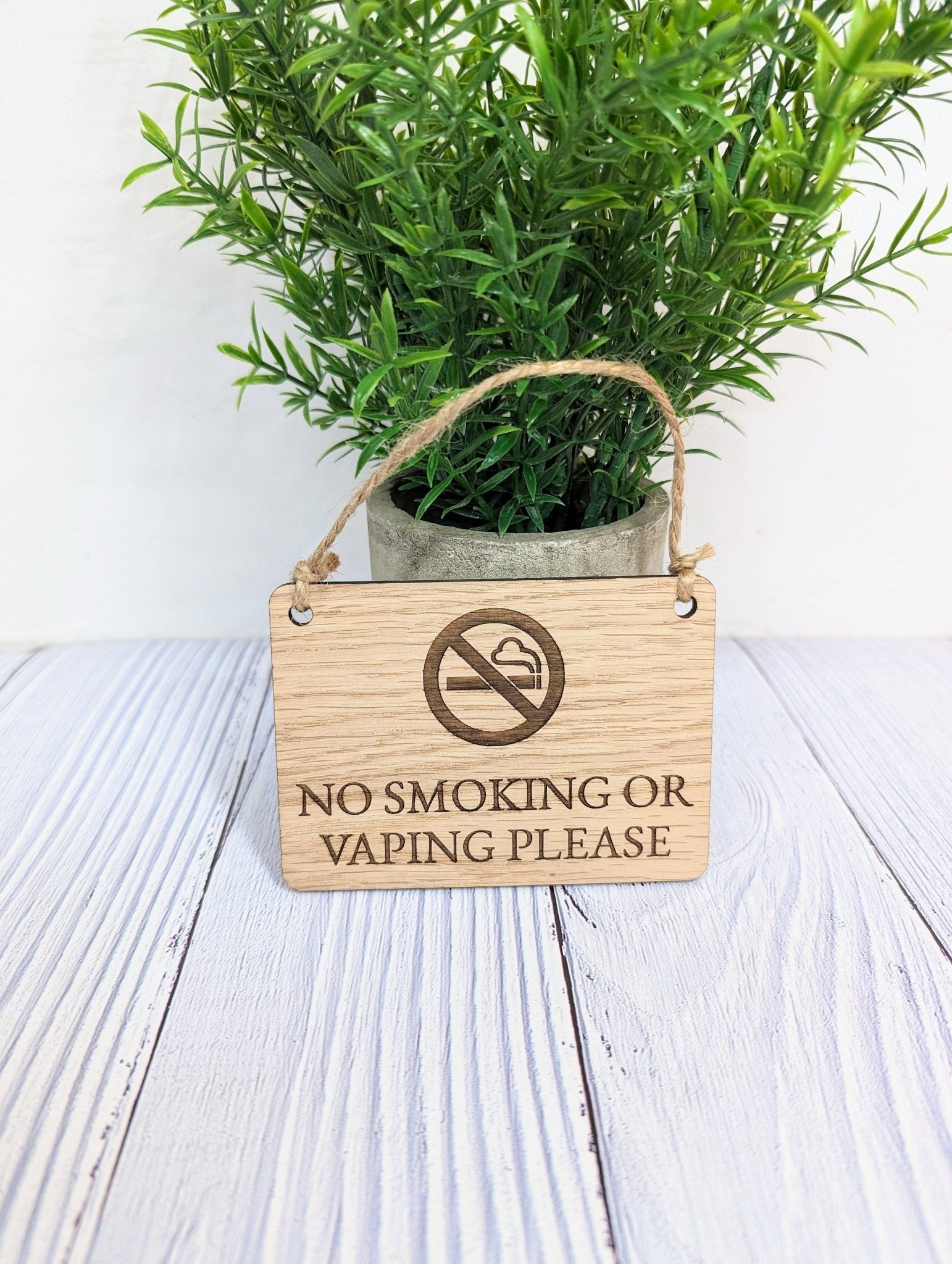 A beautifully crafted 'No Smoking or Vaping Please' wooden sign made from oak veneered MDF, showcasing its unique grain and craftsmanship.