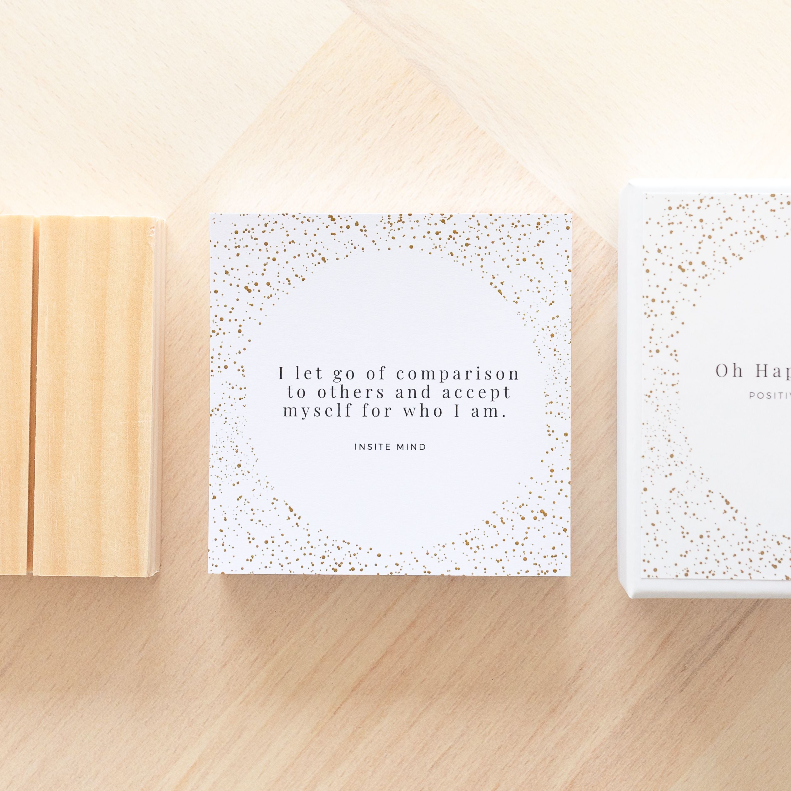 A beautifully designed set of Oh Happy Life affirmation cards displayed with a stylish card stand, featuring positive messages for daily inspiration.