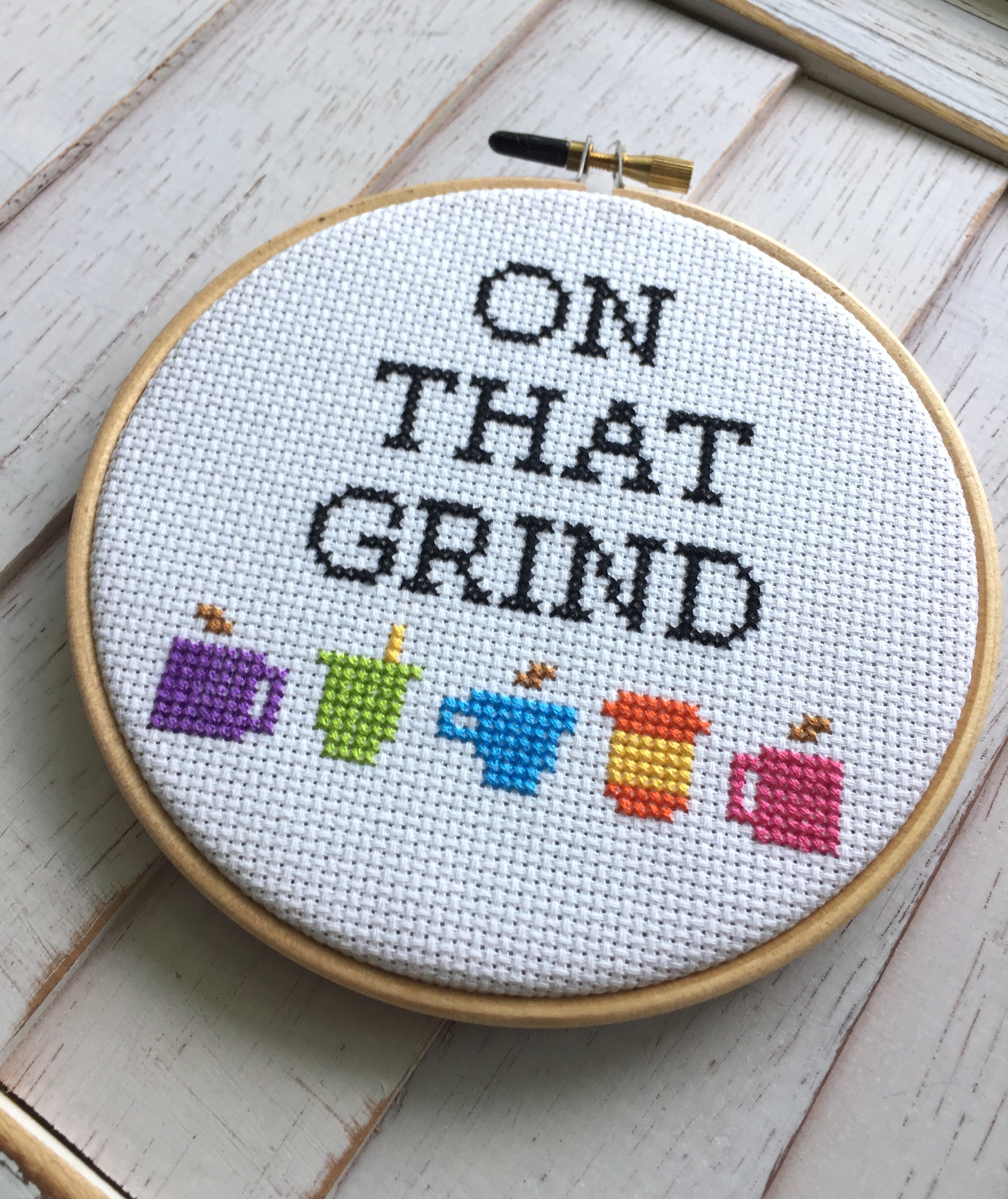 On That Grind Coffee Counted Cross Stitch DIY Kit featuring coffee cup designs and all necessary supplies for crafting.