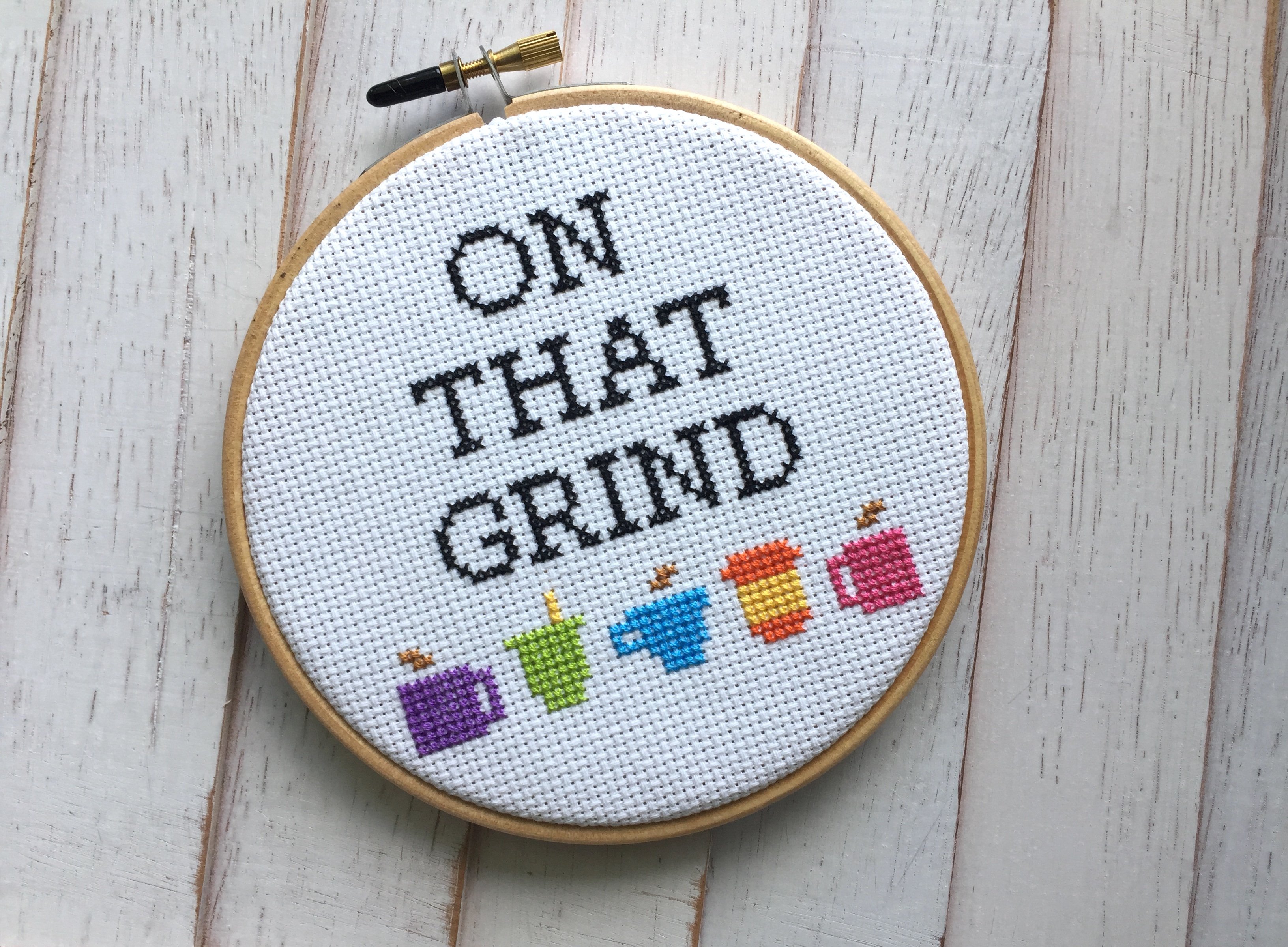 On That Grind Coffee Counted Cross Stitch DIY Kit featuring coffee cup designs and all necessary supplies for crafting.