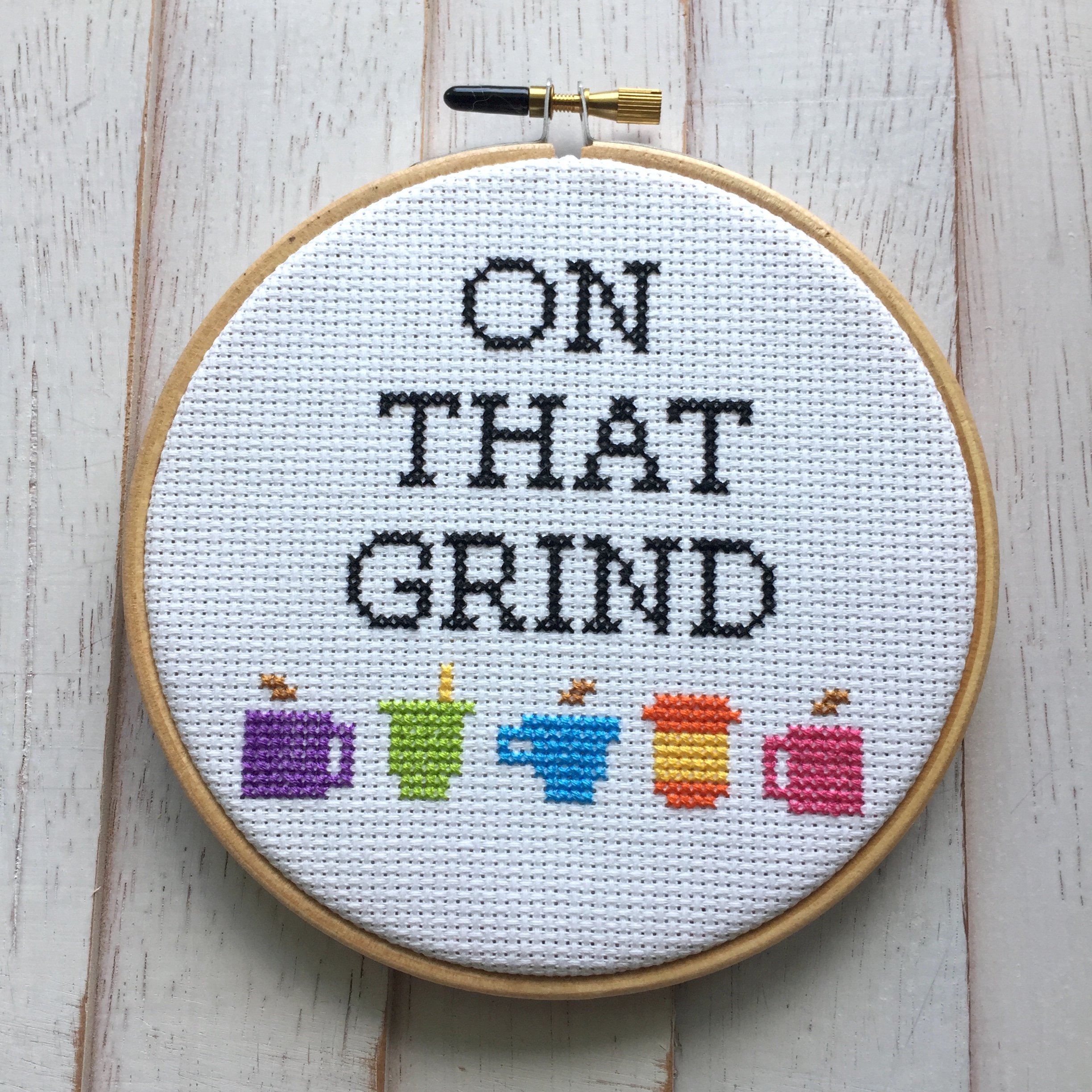 On That Grind Coffee Counted Cross Stitch DIY Kit featuring coffee cup designs and all necessary supplies for crafting.