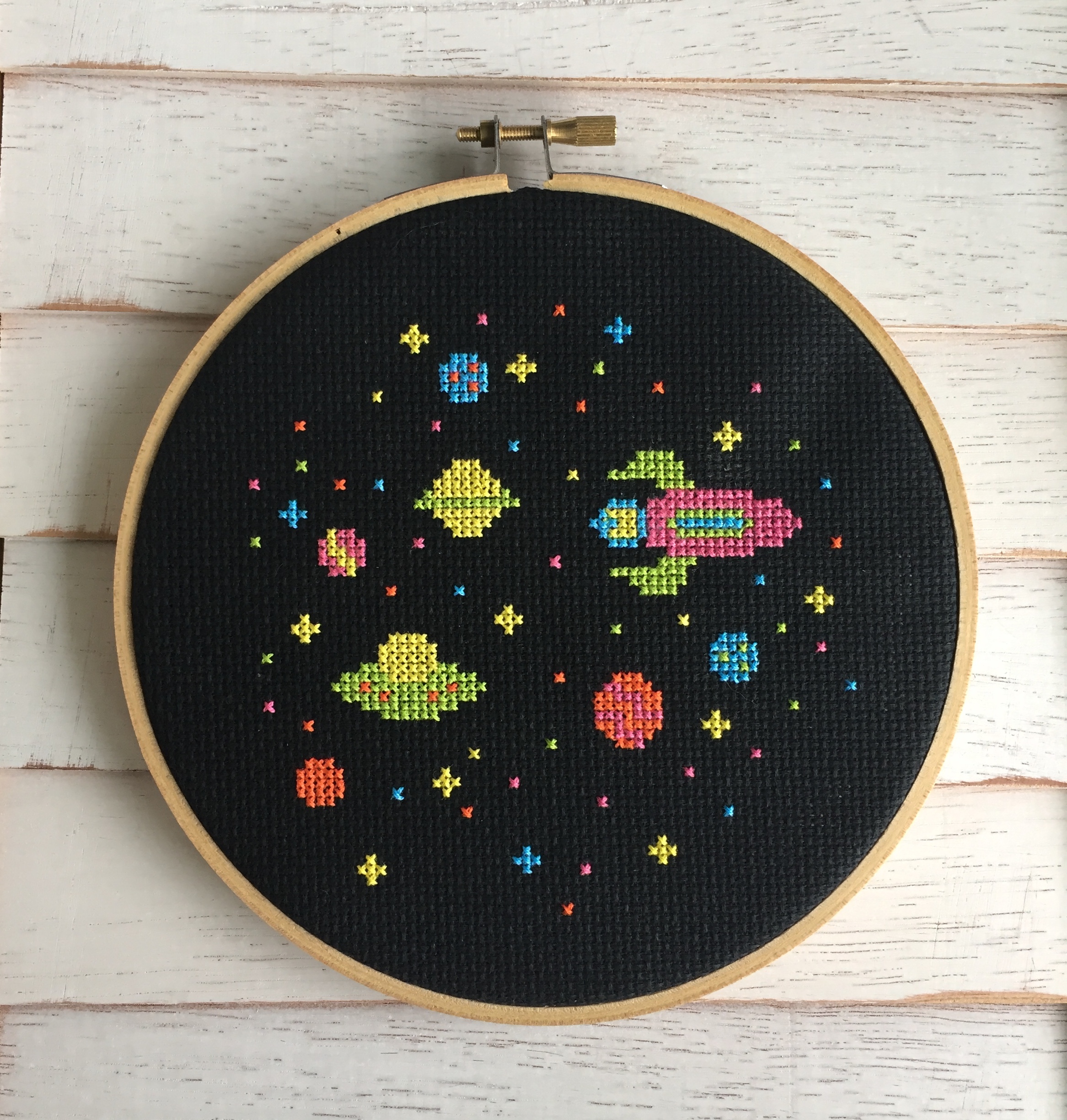 Colorful counted cross stitch kit featuring a rocket ship, planets, and stars, perfect for beginners.