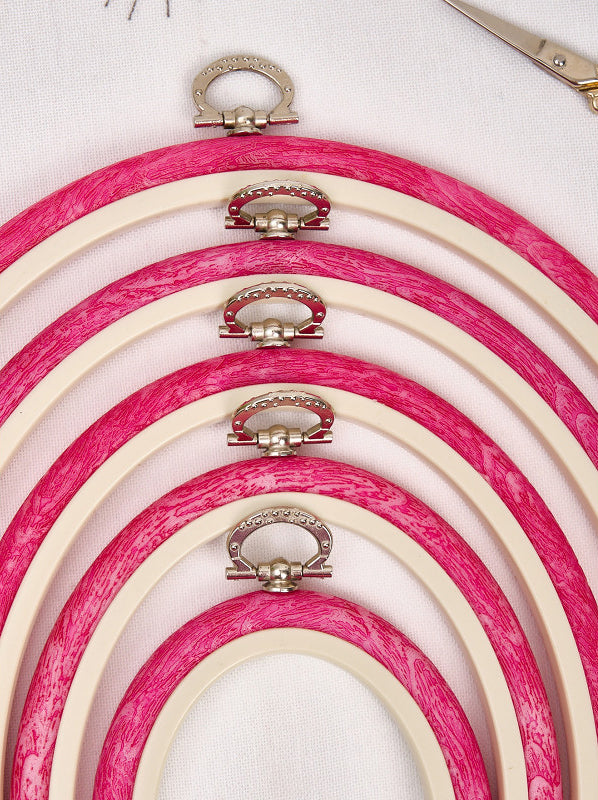 Nurge 230-7 Pink Flexi Hoop, oval embroidery tool with rubberized outer and decorative hook for hanging.