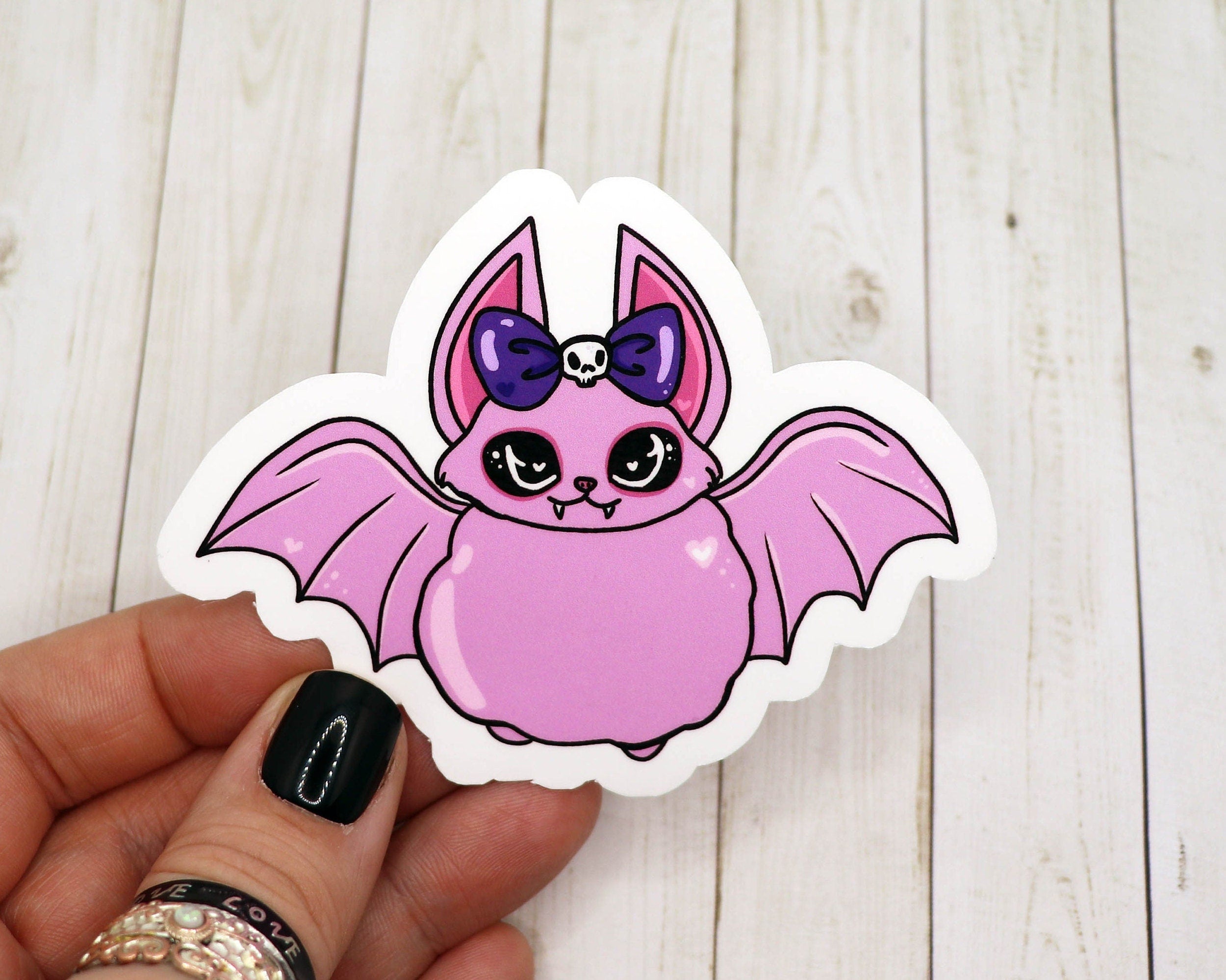 A pastel goth pink bat sticker featuring a cute bat design in soft pastel colors, perfect for personalizing various items.