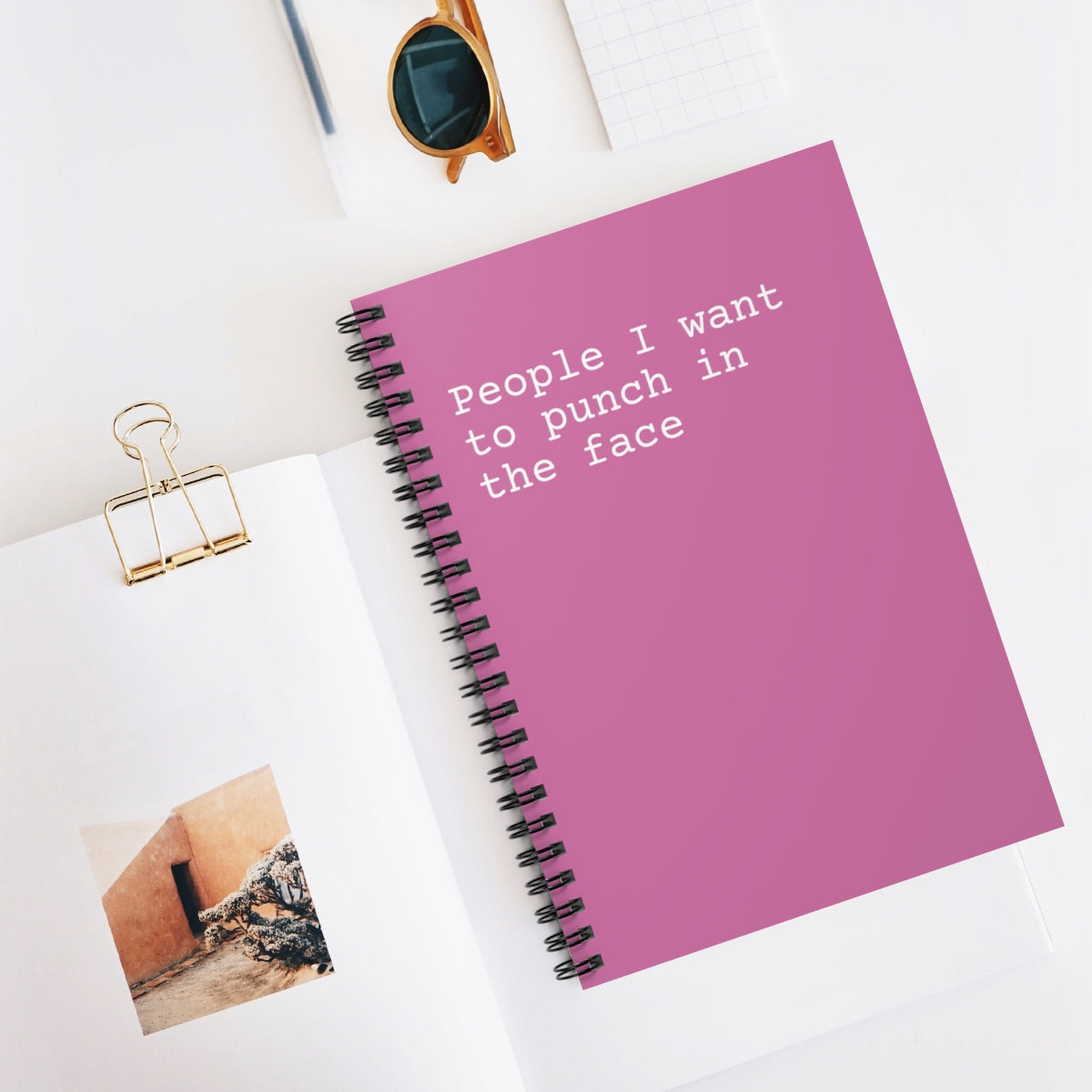 A spiral notebook featuring a humorous cover design that reads 'People I Want to Punch in the Face', with ruled line pages inside.