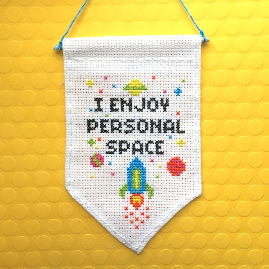 Personal Space Tiny Banner Counted Cross Stitch Kit featuring neon threads on white aida cloth, includes all necessary supplies.