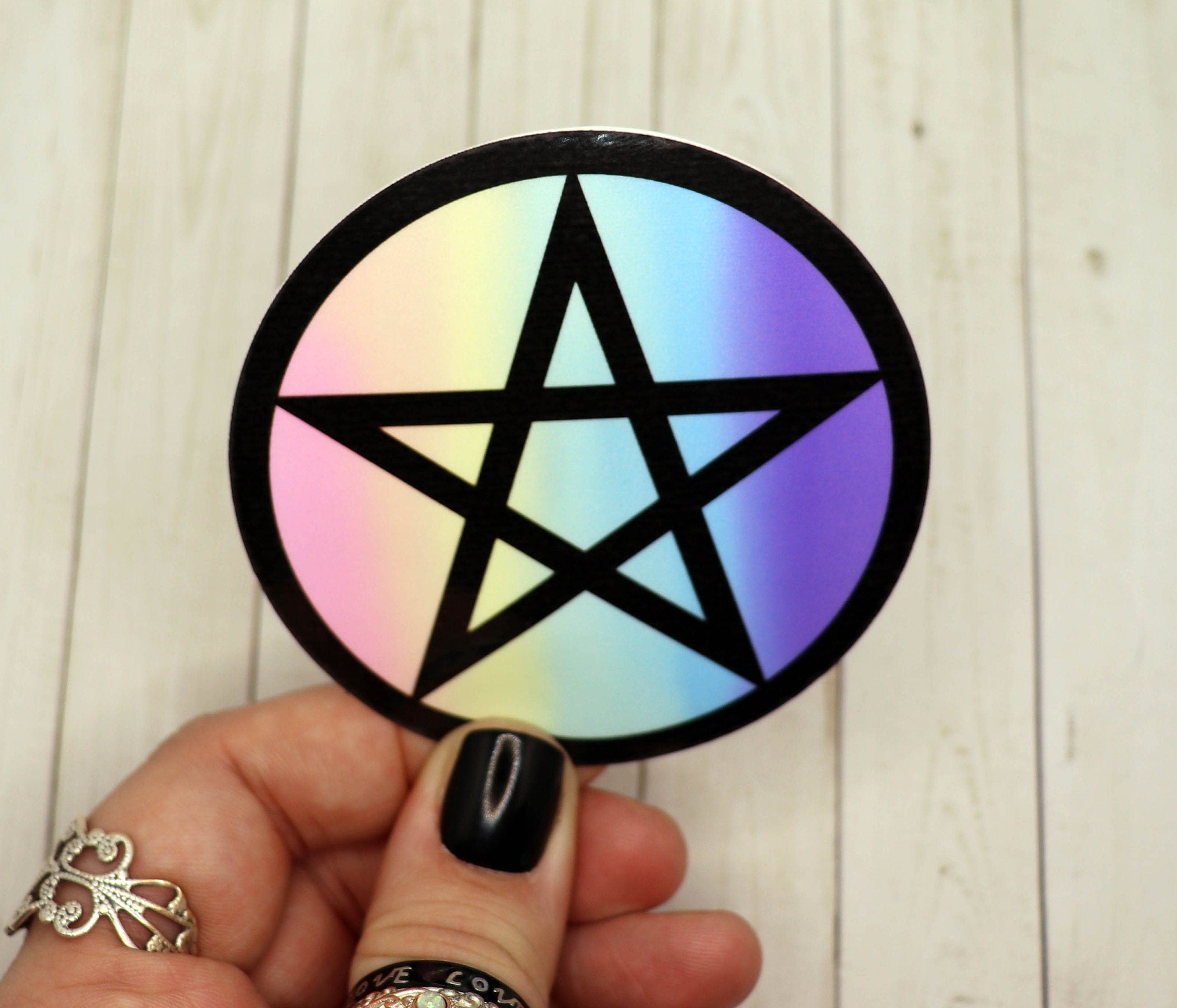 A vibrant pink and black pentagram sticker on a white background, showcasing its intricate design and matte finish.