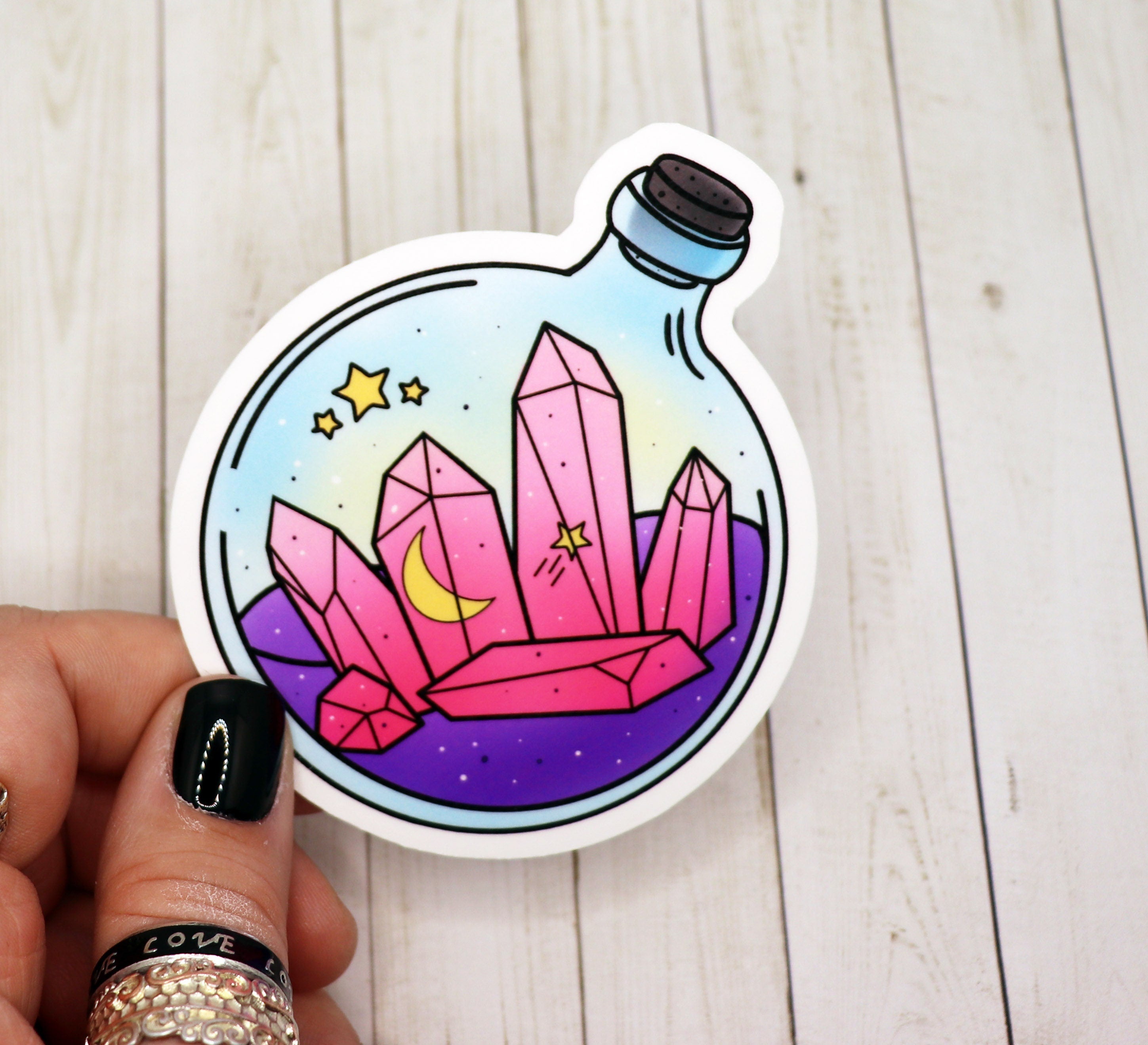 A vibrant pink crystal potion bottle sticker on a white background, showcasing its intricate design and matte finish.