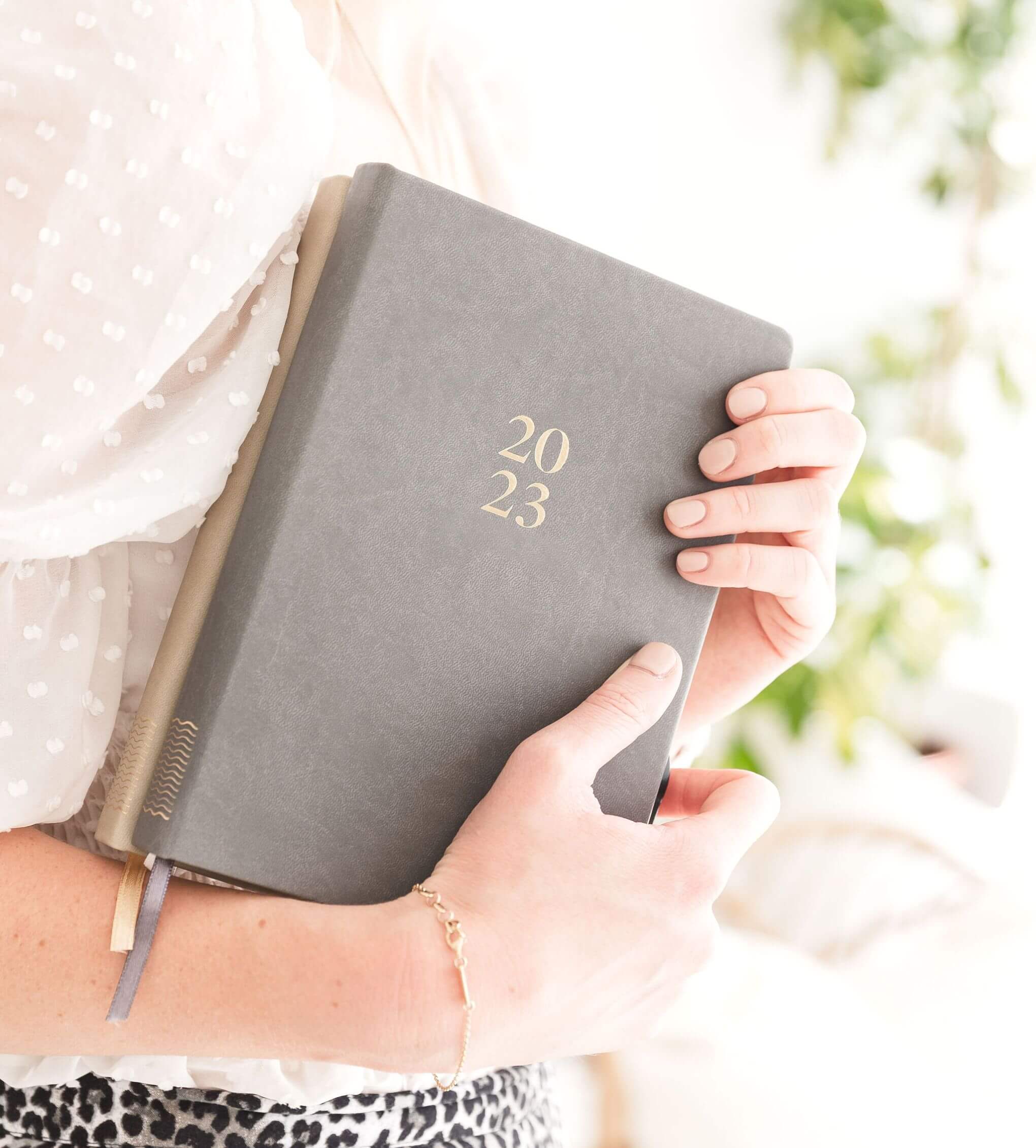 Person holding 2023 planner notebook.