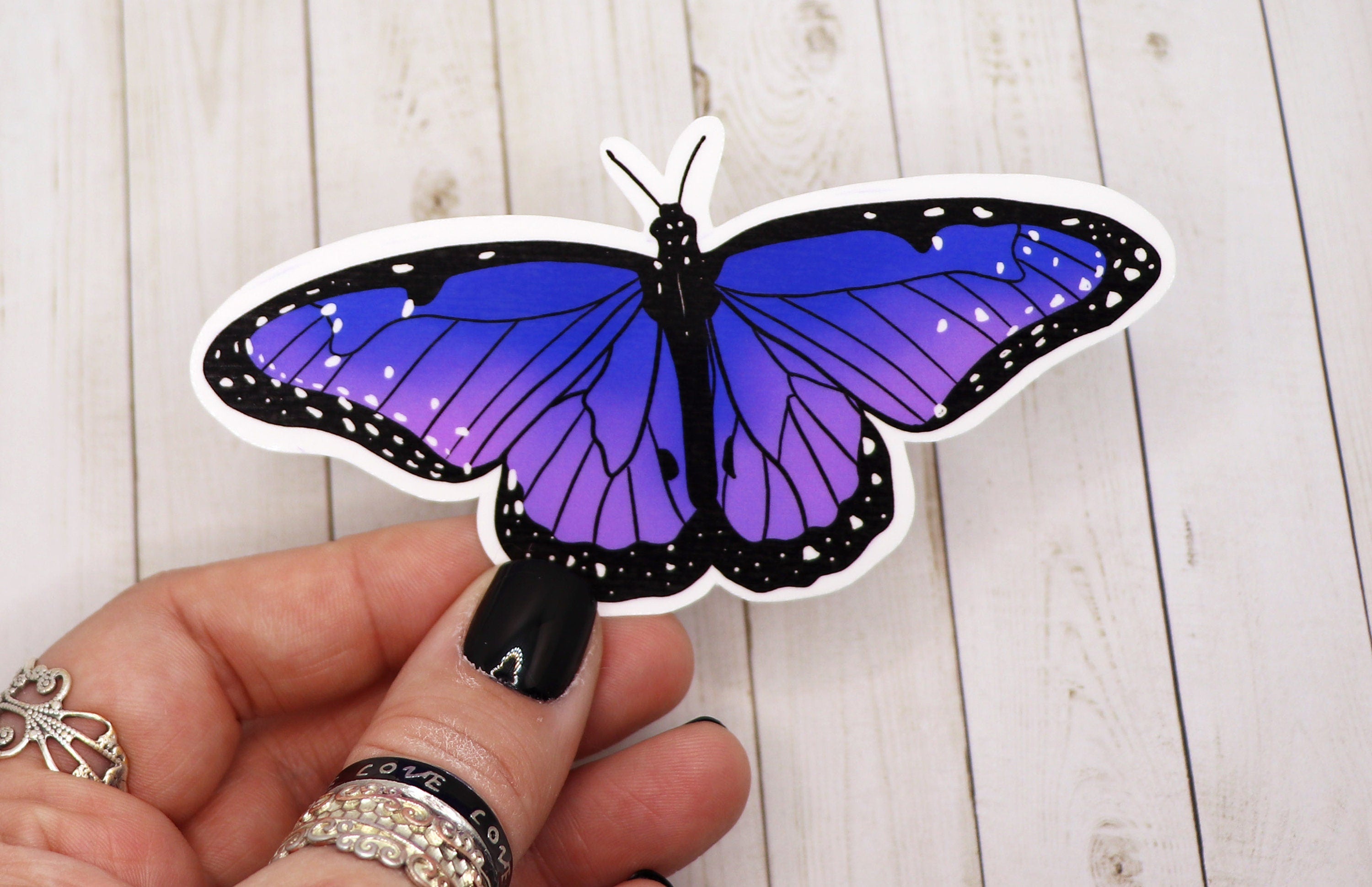 A vibrant purple butterfly sticker on a white background, showcasing intricate details and a matte finish.