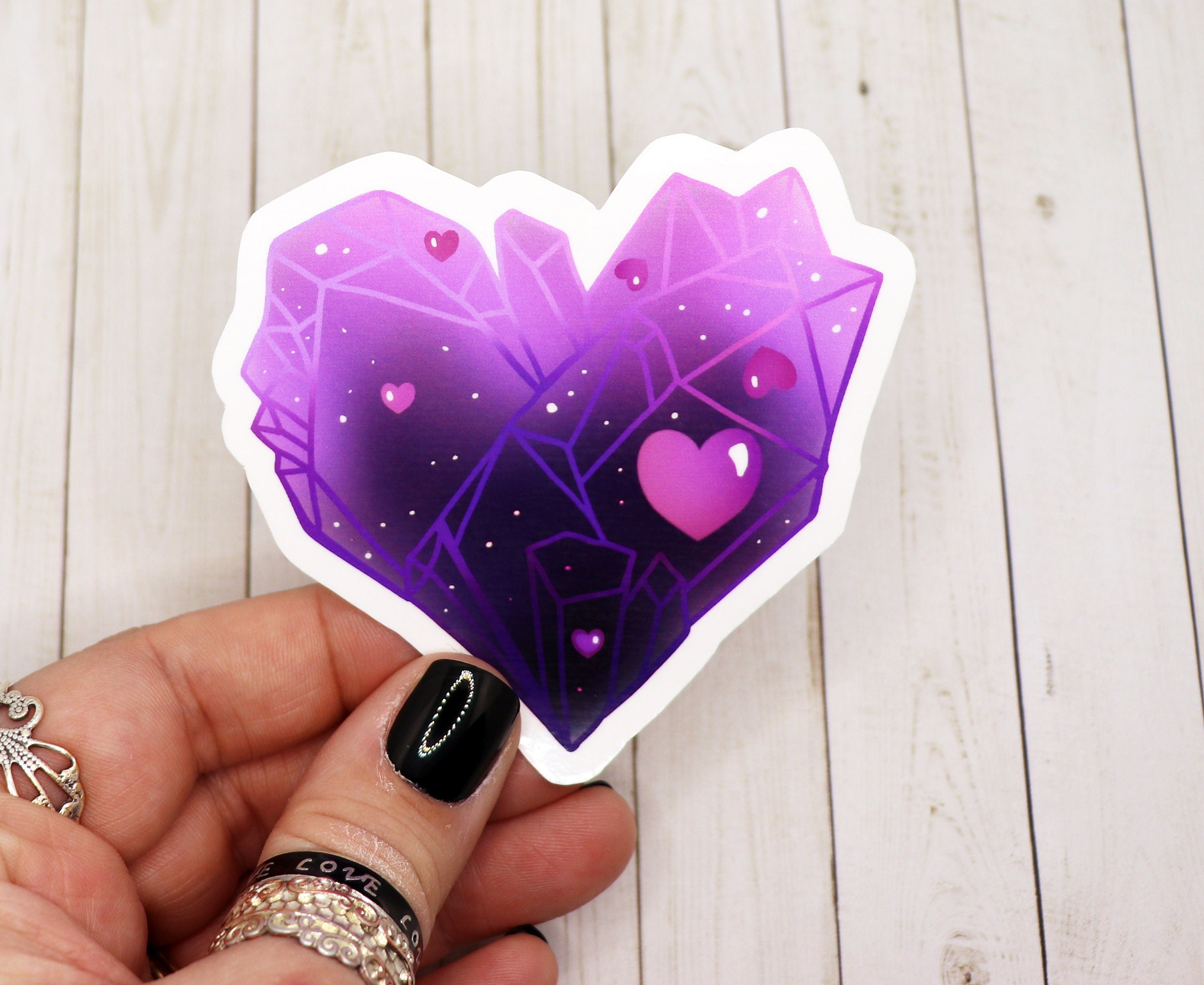 Purple crystal heart sticker on a white background, showcasing its vibrant color and glossy finish.