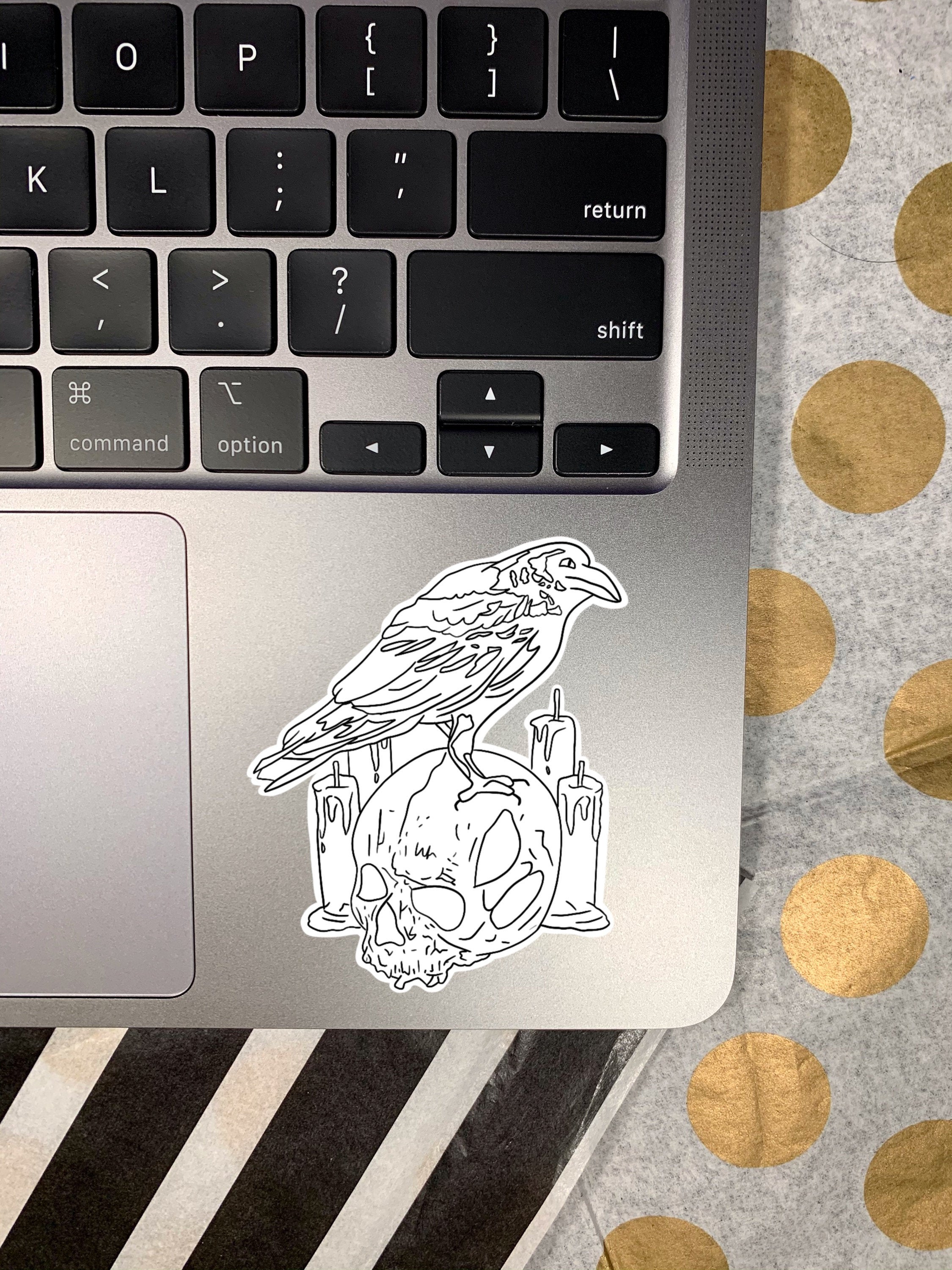 A detailed raven skull sticker featuring intricate designs, perfect for personalizing items like laptops and water bottles.