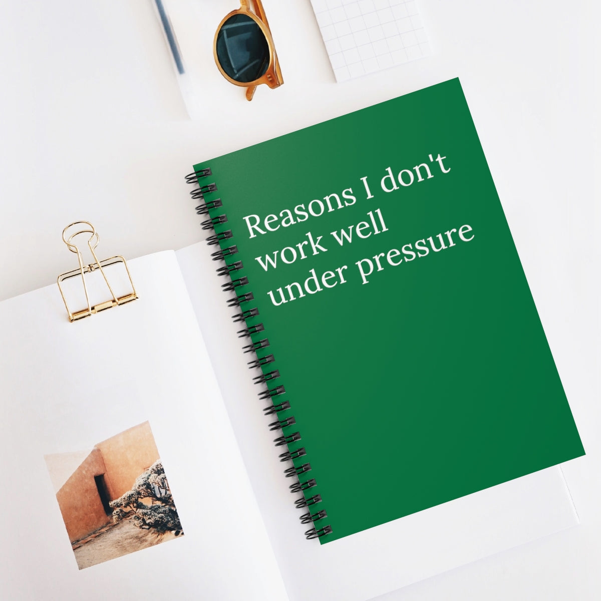 A spiral-bound funny notebook titled 'Reasons I Don't Work Well Under Pressure' with ruled line pages, perfect for office humor.