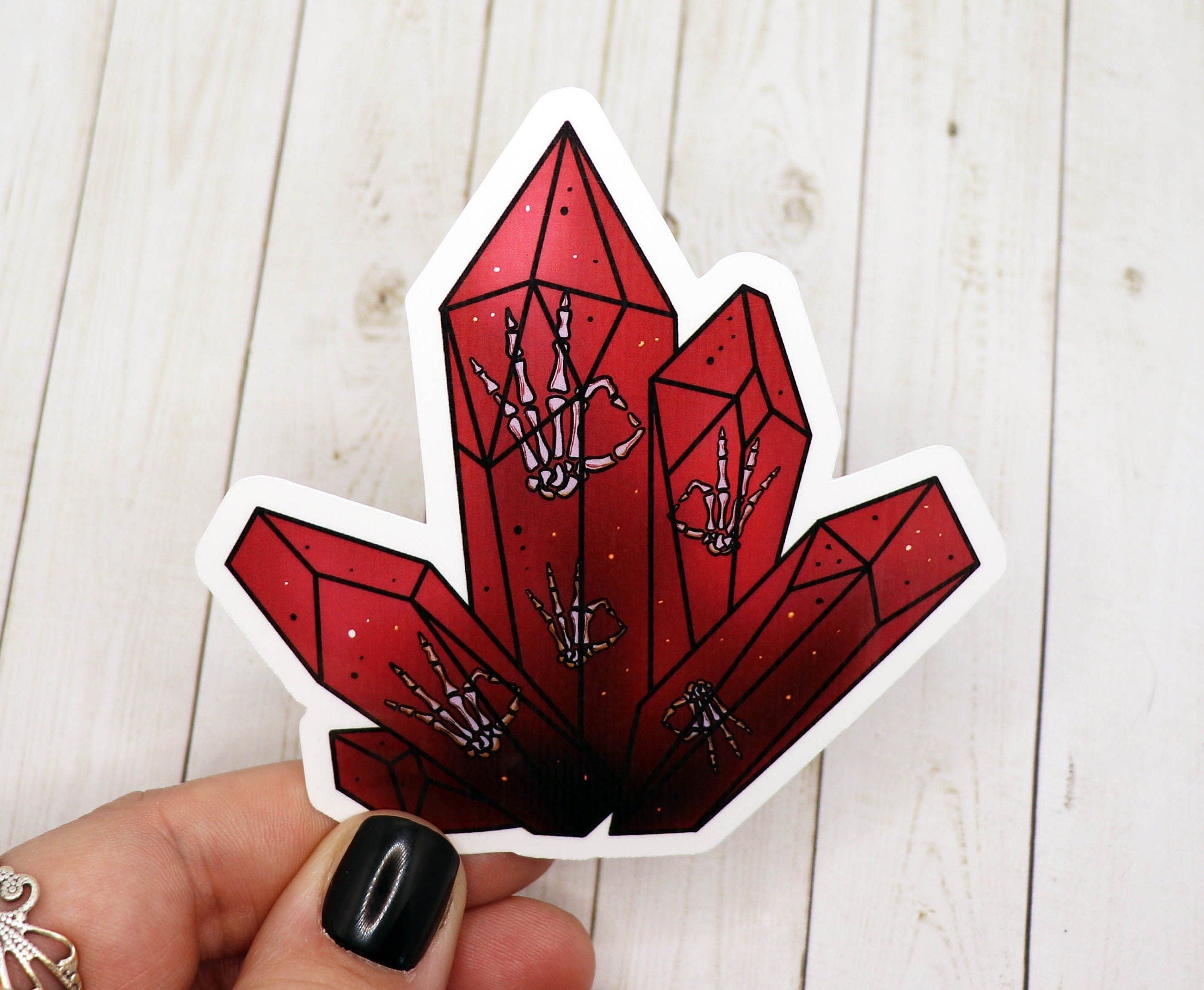 Red crystal sticker featuring skeleton hands, designed for personalizing various items.