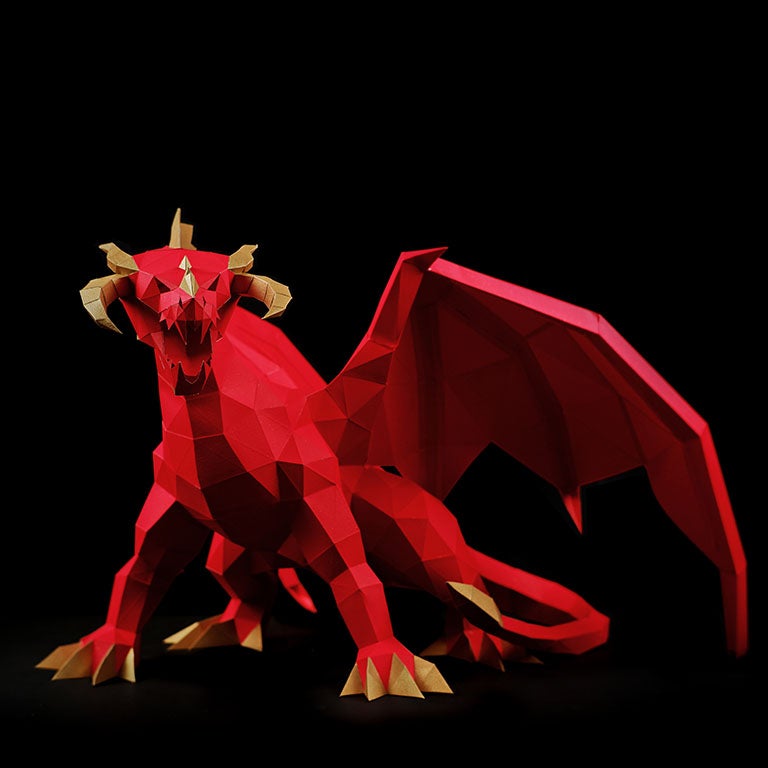 A stunning red and gold paper dragon model in a predatory stance with wings spread, showcasing intricate details and craftsmanship.