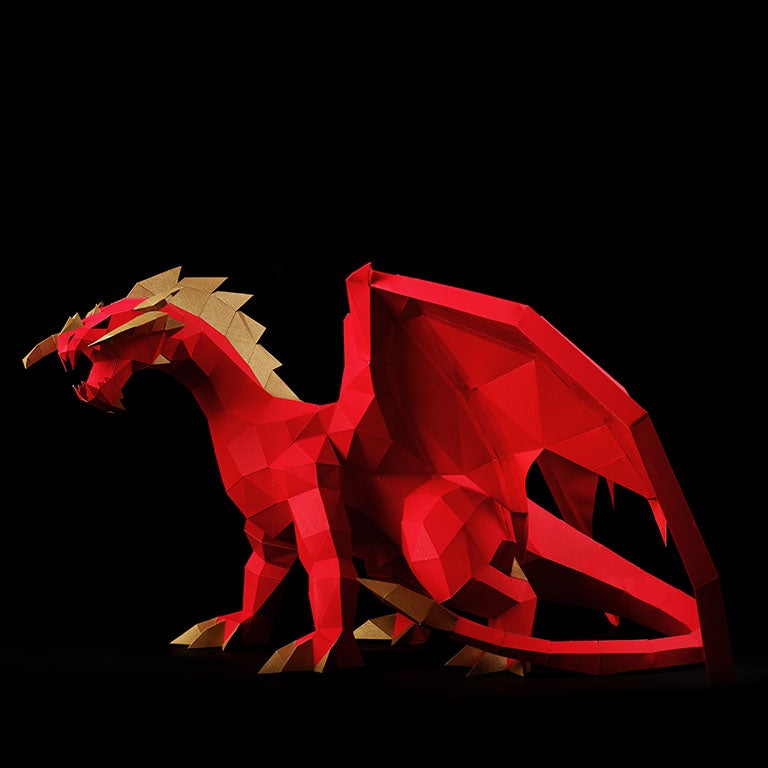 A stunning red and gold paper dragon model in a predatory stance with wings spread, showcasing intricate details and craftsmanship.