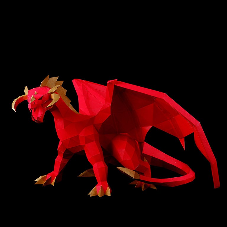 A stunning red and gold paper dragon model in a predatory stance with wings spread, showcasing intricate details and craftsmanship.