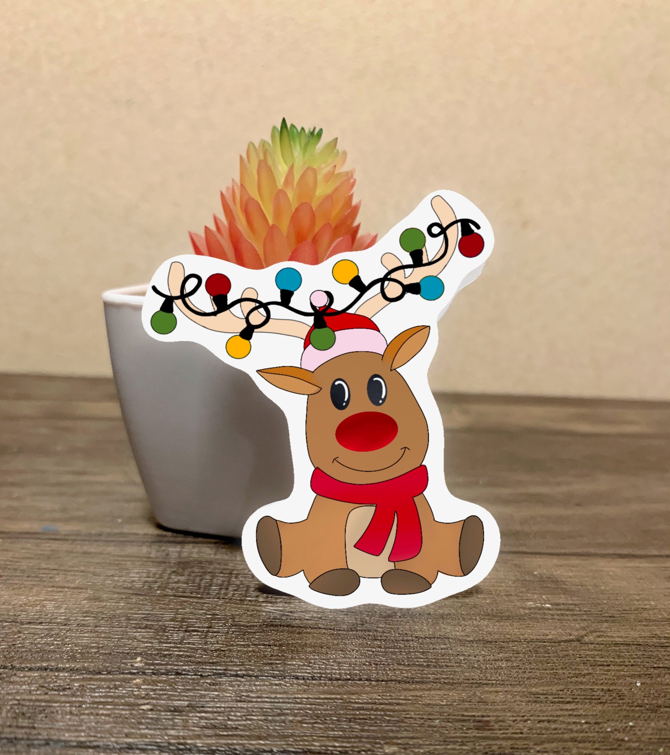 A cute reindeer sticker featuring a whimsical design, perfect for personalizing items like hydroflasks and laptops.