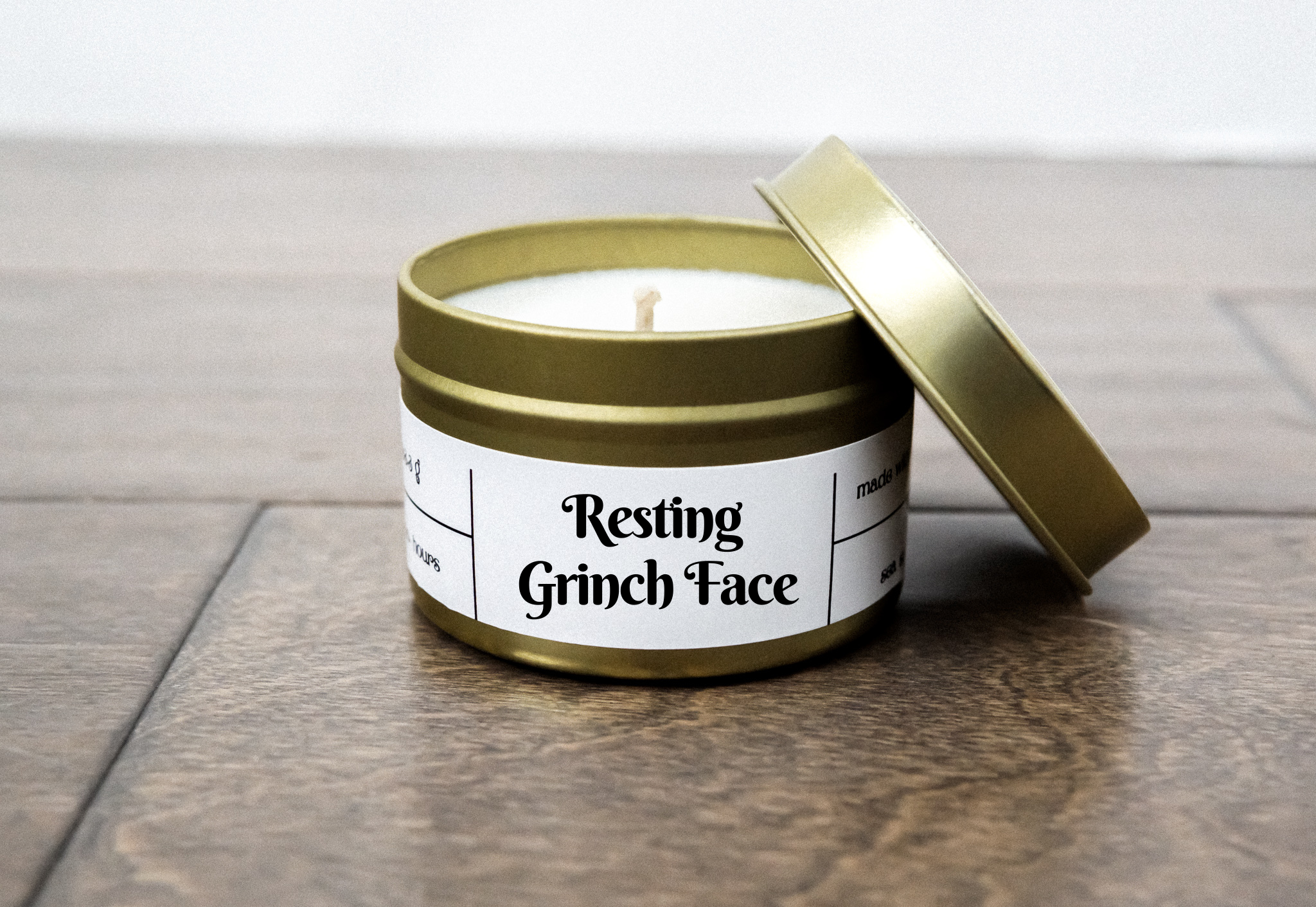 Resting Grinch Face candle in a 4oz jar, featuring a woodsy fragrance blend of white birch wood, cypress pine, and smoke.