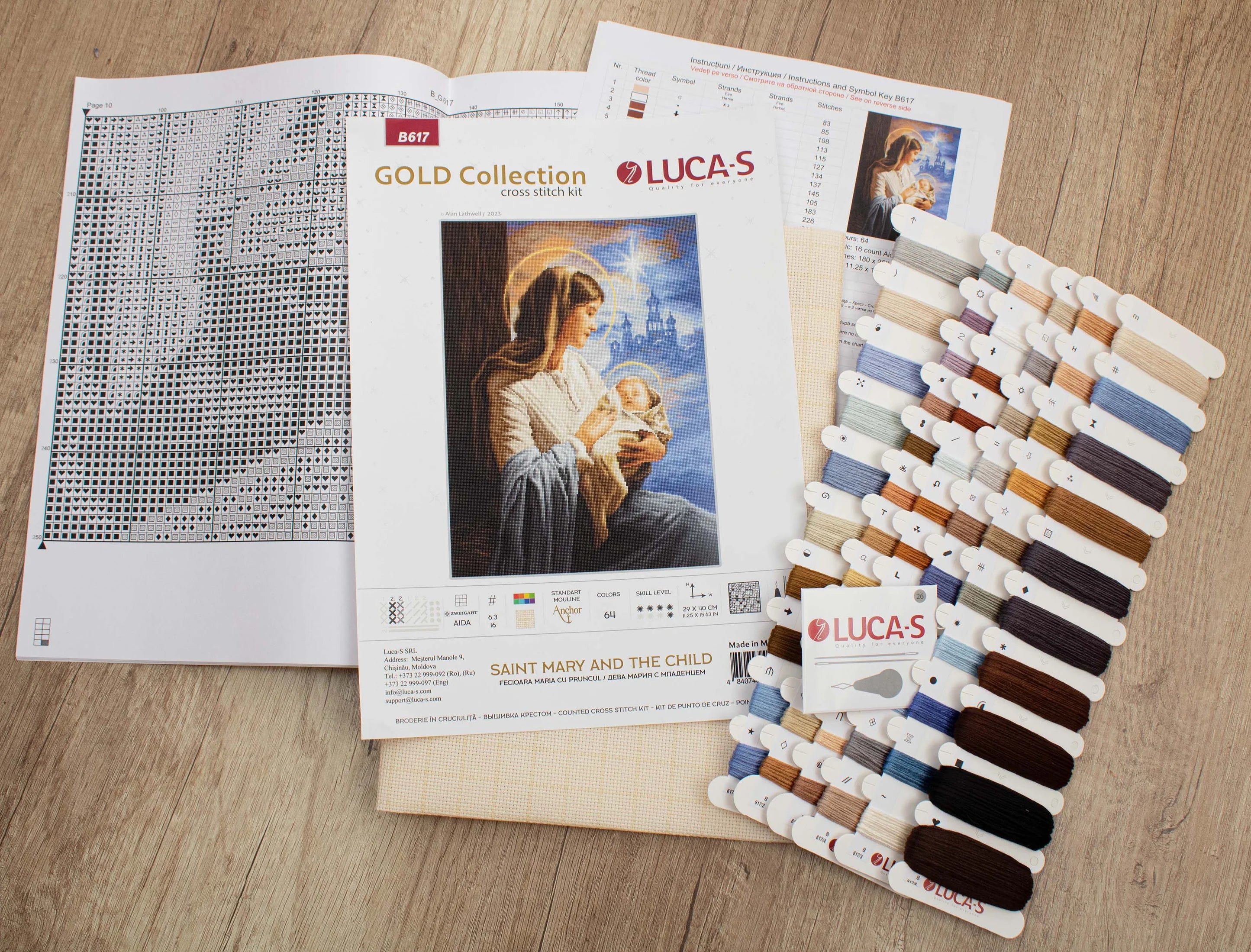 Saint Mary and The Child Counted Cross-Stitch Kit featuring Aida canvas, colorful threads, and needle for crafting.