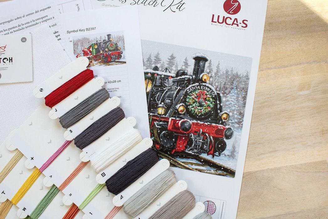 Santa's Express B2397L counted cross-stitch kit featuring Santa Claus and a colorful train filled with gifts in a winter landscape.