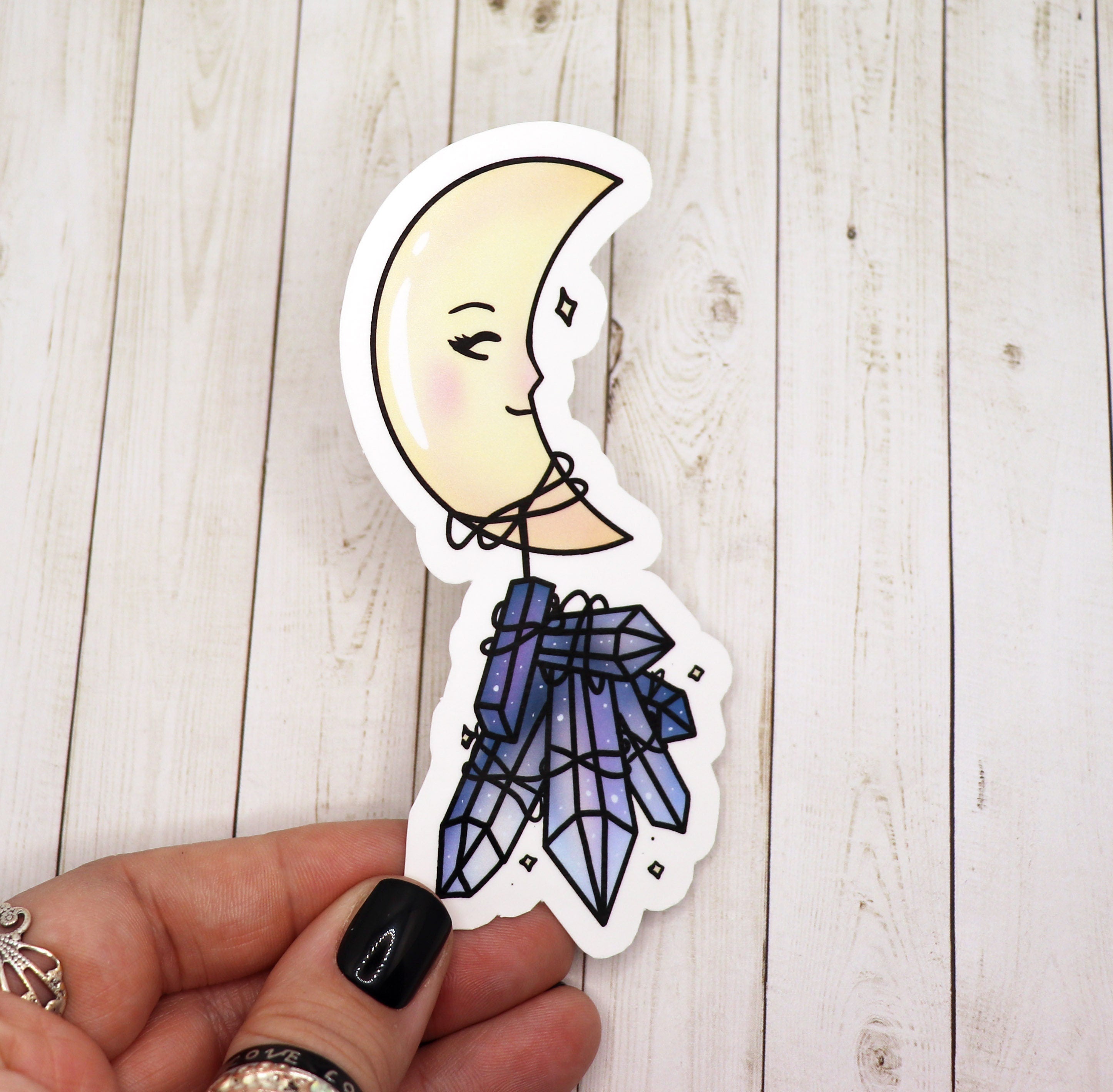 A whimsical Sleepy Moon and Crystal Sticker featuring a serene moon design with sparkling crystals, printed on high-quality matte vinyl.