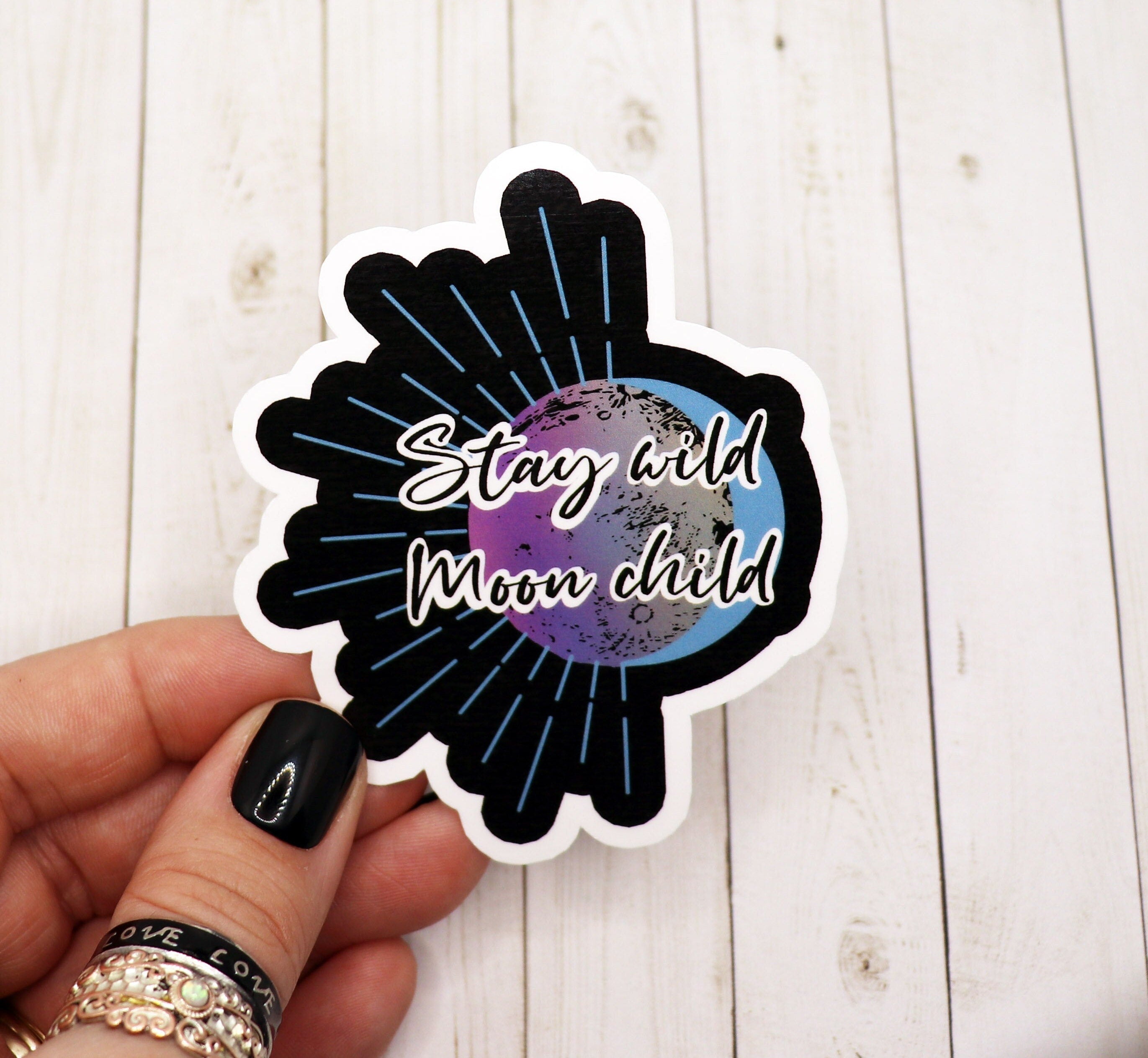 Stay Wild Moon Child quote sticker on a matte vinyl surface, showcasing its vibrant design and 3-inch size.