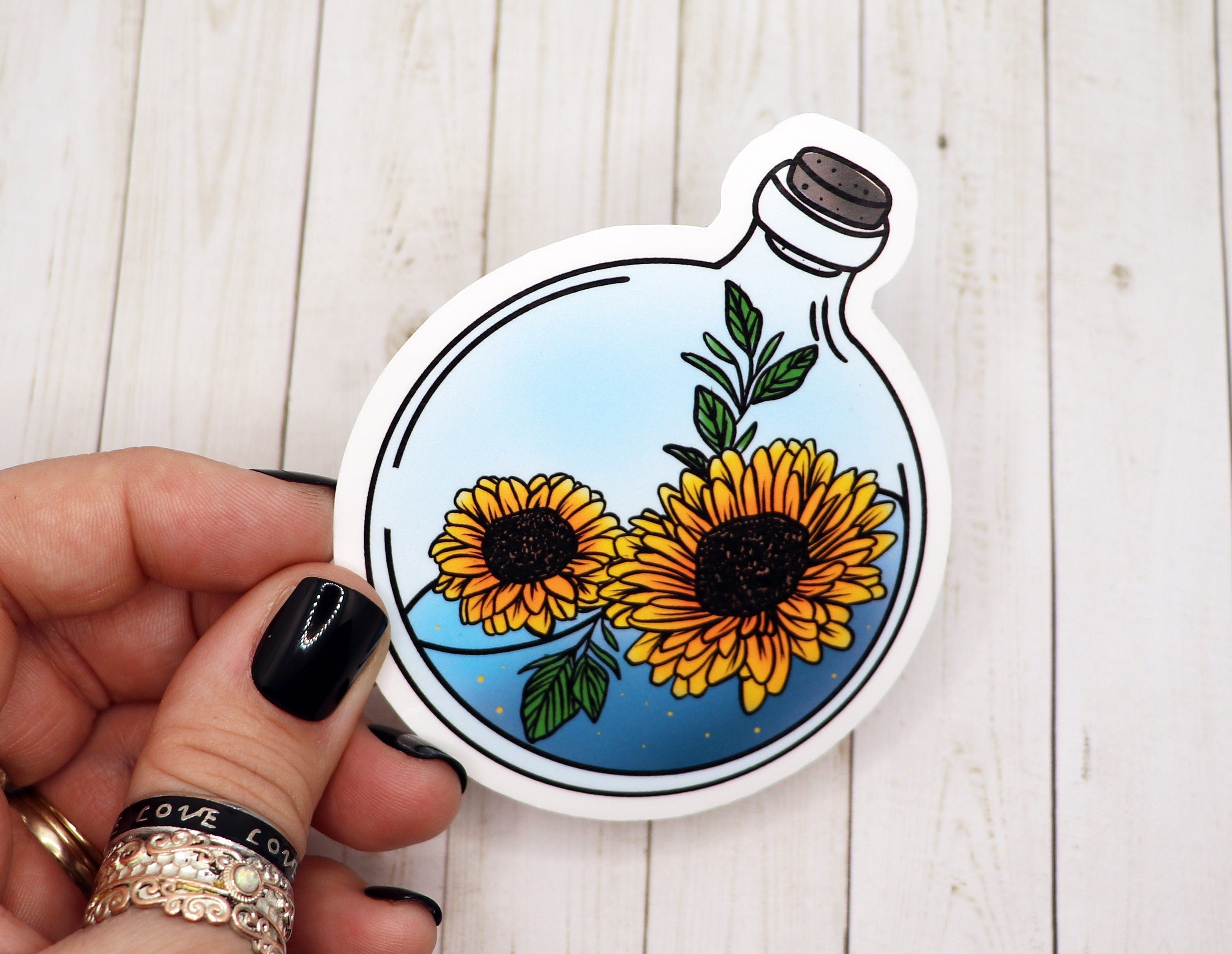 A vibrant sunflower potion bottle sticker on a white background, showcasing its colorful design and matte finish.