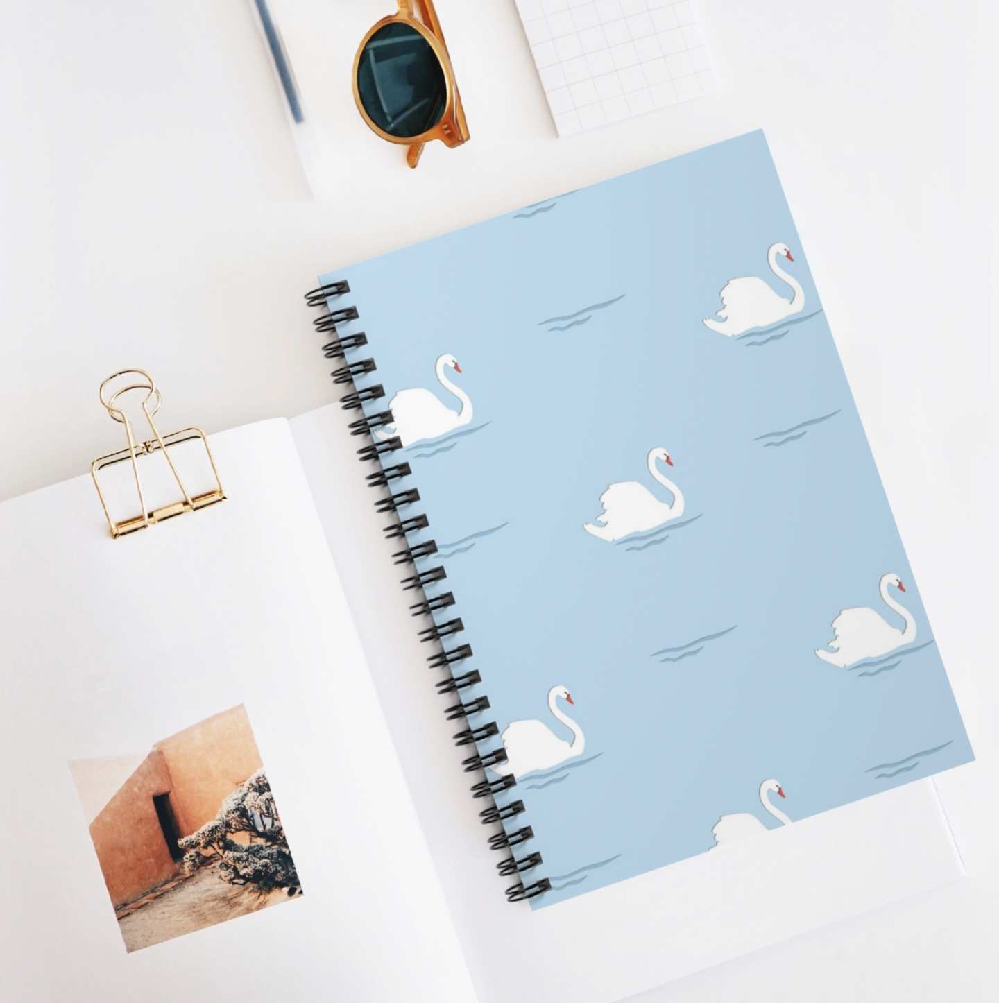 Swans Lined Notebook featuring black spiral binding and 100 lined pages in A5 size.