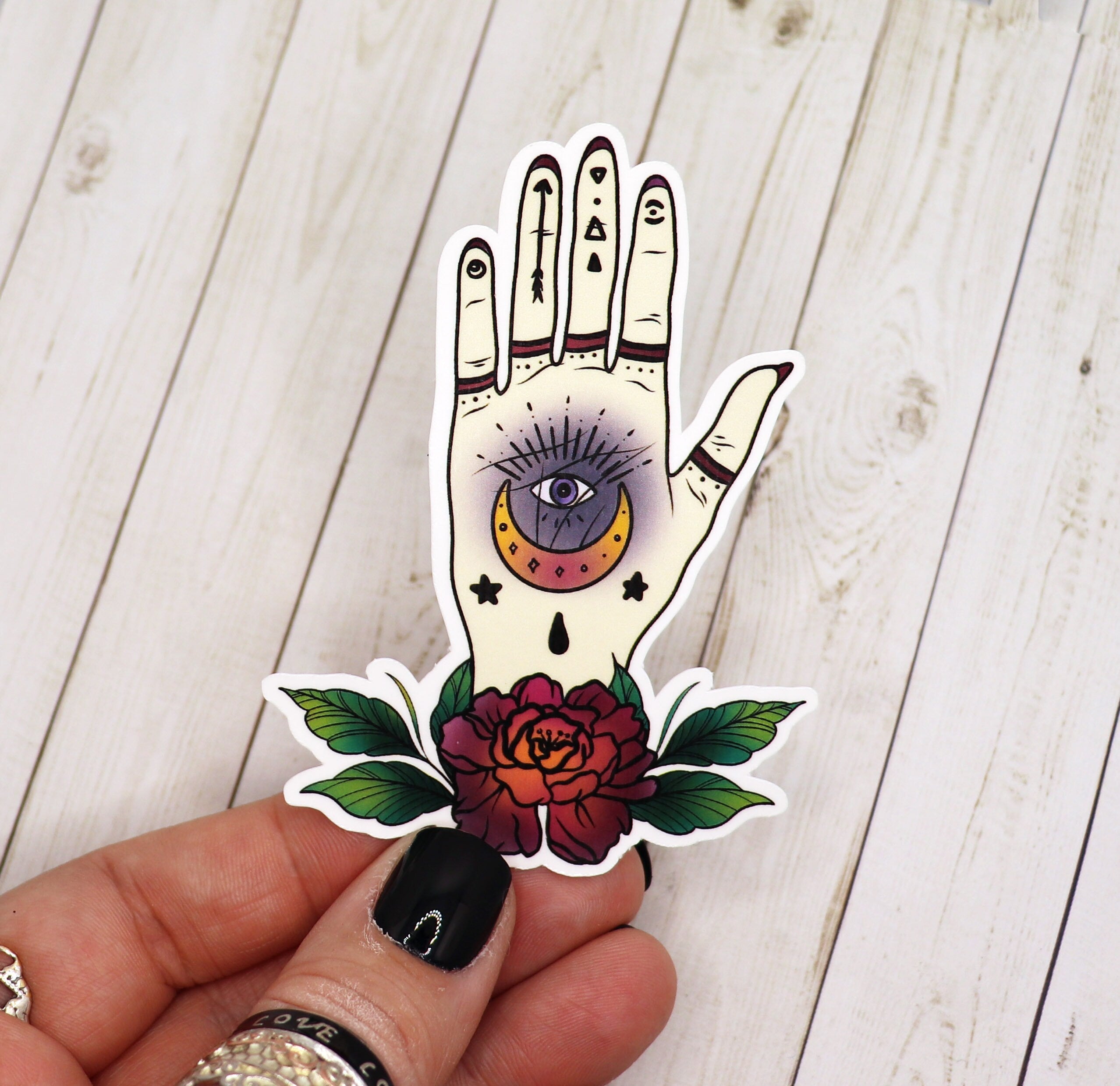 Tattoo style occult hamsa hand sticker on a white background, showcasing intricate design and vibrant colors.