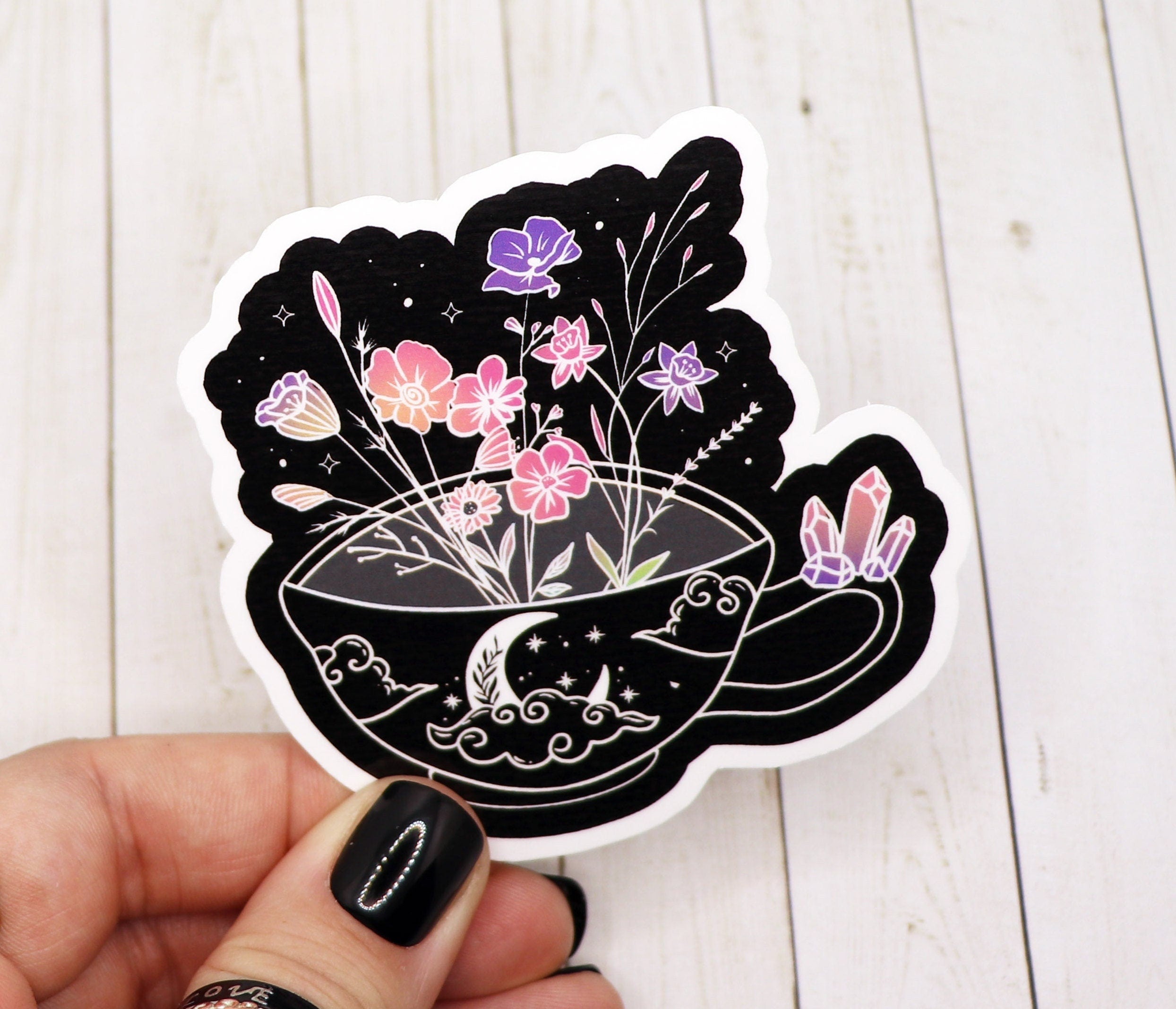 A vibrant tea cup sticker adorned with colorful flowers, perfect for personalizing various items.