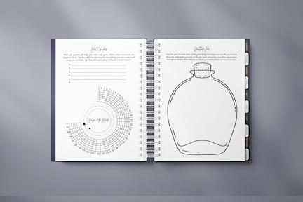 The Manifestation Planner featuring a foil embossed cover with the phrase 'Plan Attract Manifest' on the front.