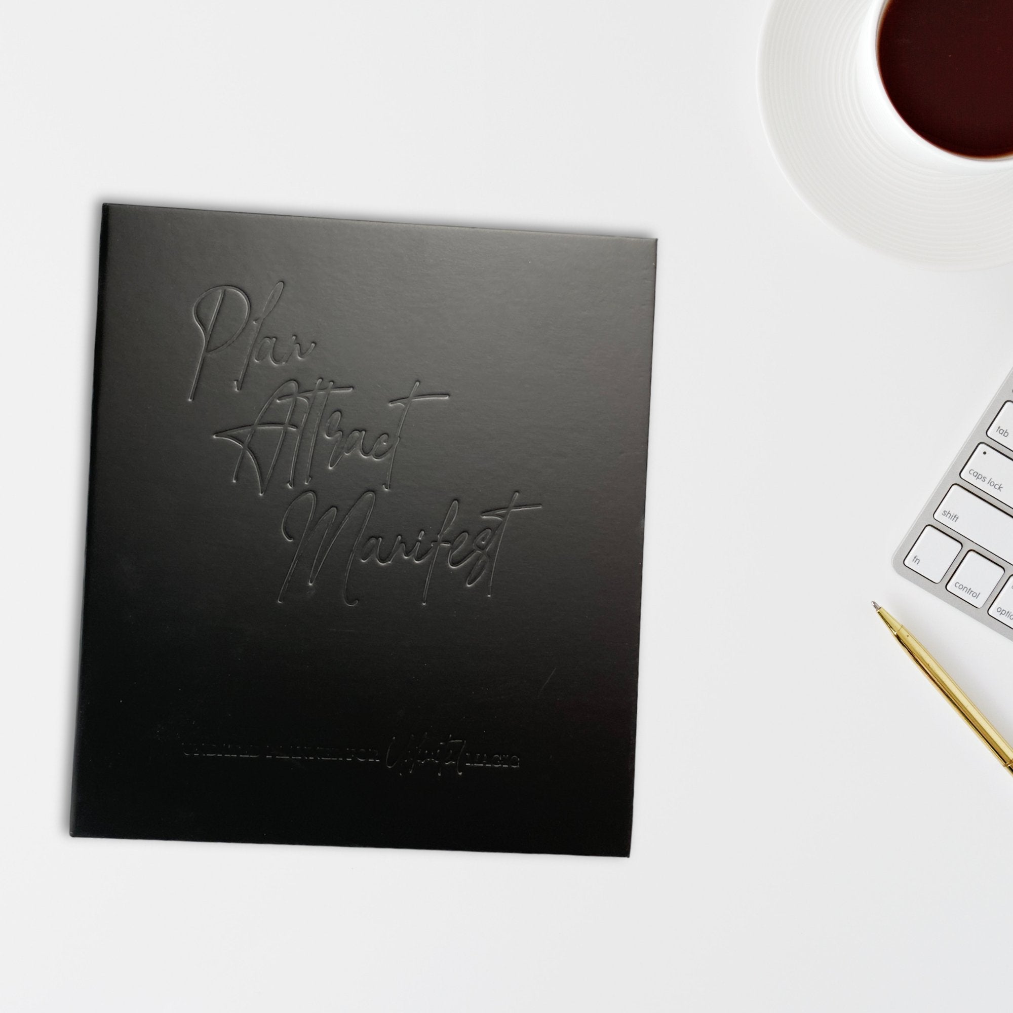 The Manifestation Planner featuring a foil embossed cover with the phrase 'Plan Attract Manifest' on the front.