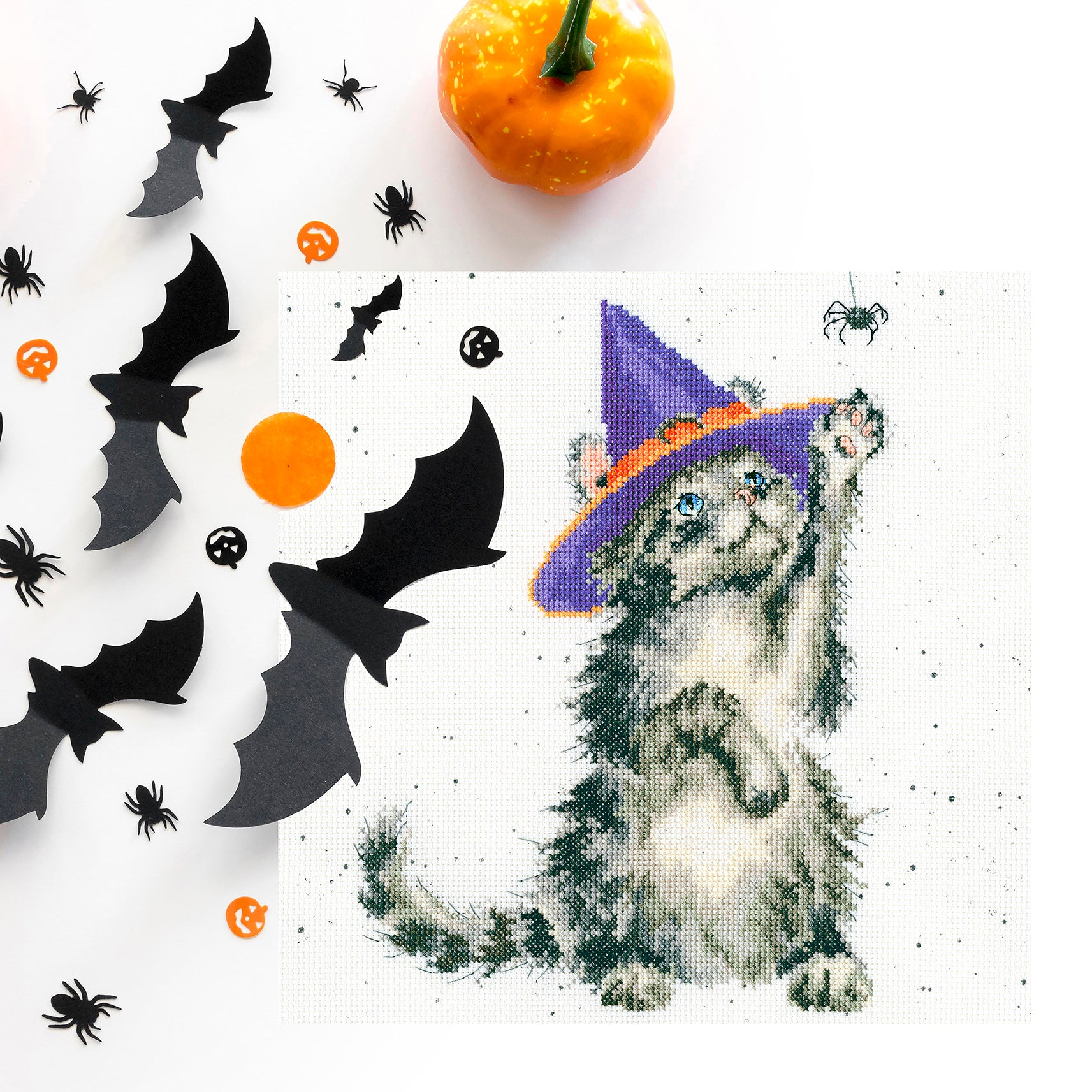 The Witch's Cat XHD105 Counted Cross Stitch Kit featuring a whimsical cat design on speckled Aida fabric with threads and needle.