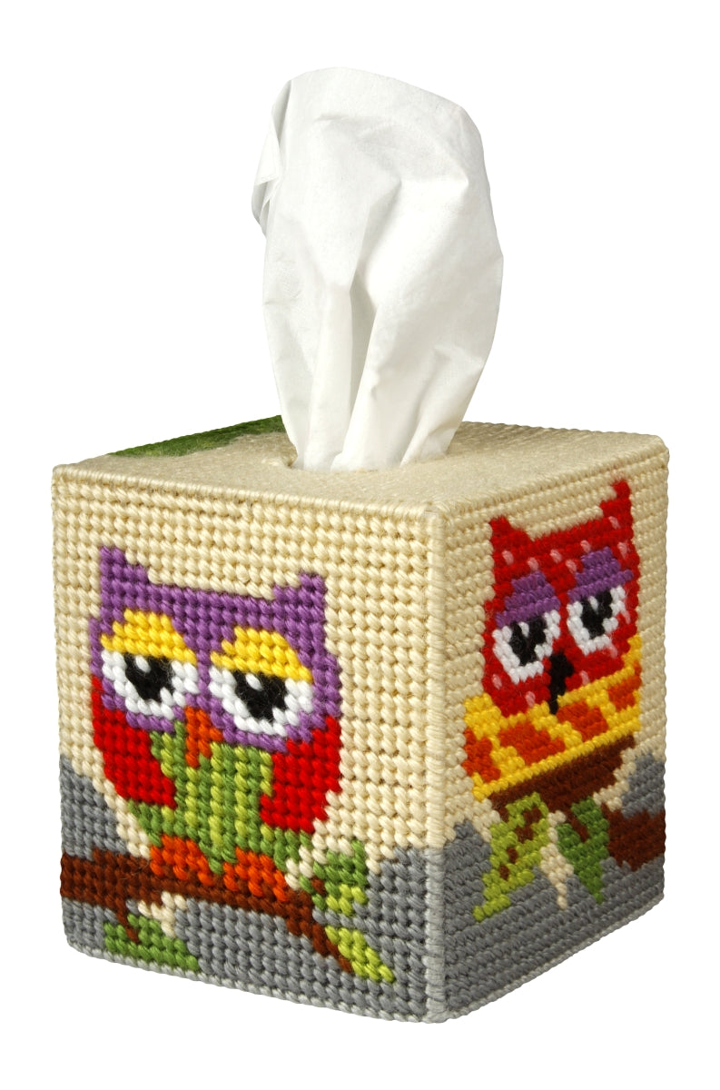 A colorful needlepoint kit featuring an owl design for a tissue box cover, including yarn, plastic canvas, and instructions.